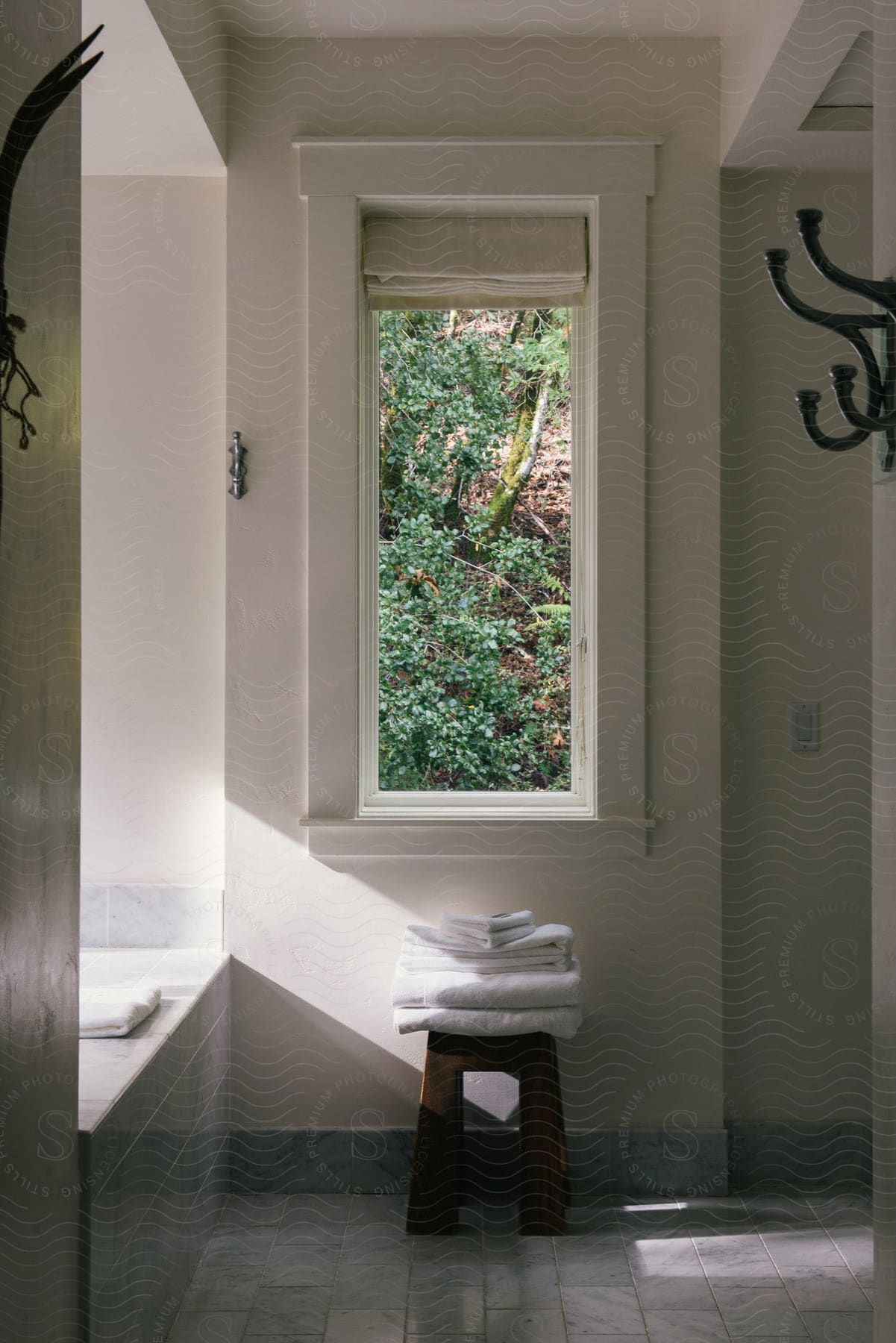 An empty bathroom with wooden floors a window and a windowsill