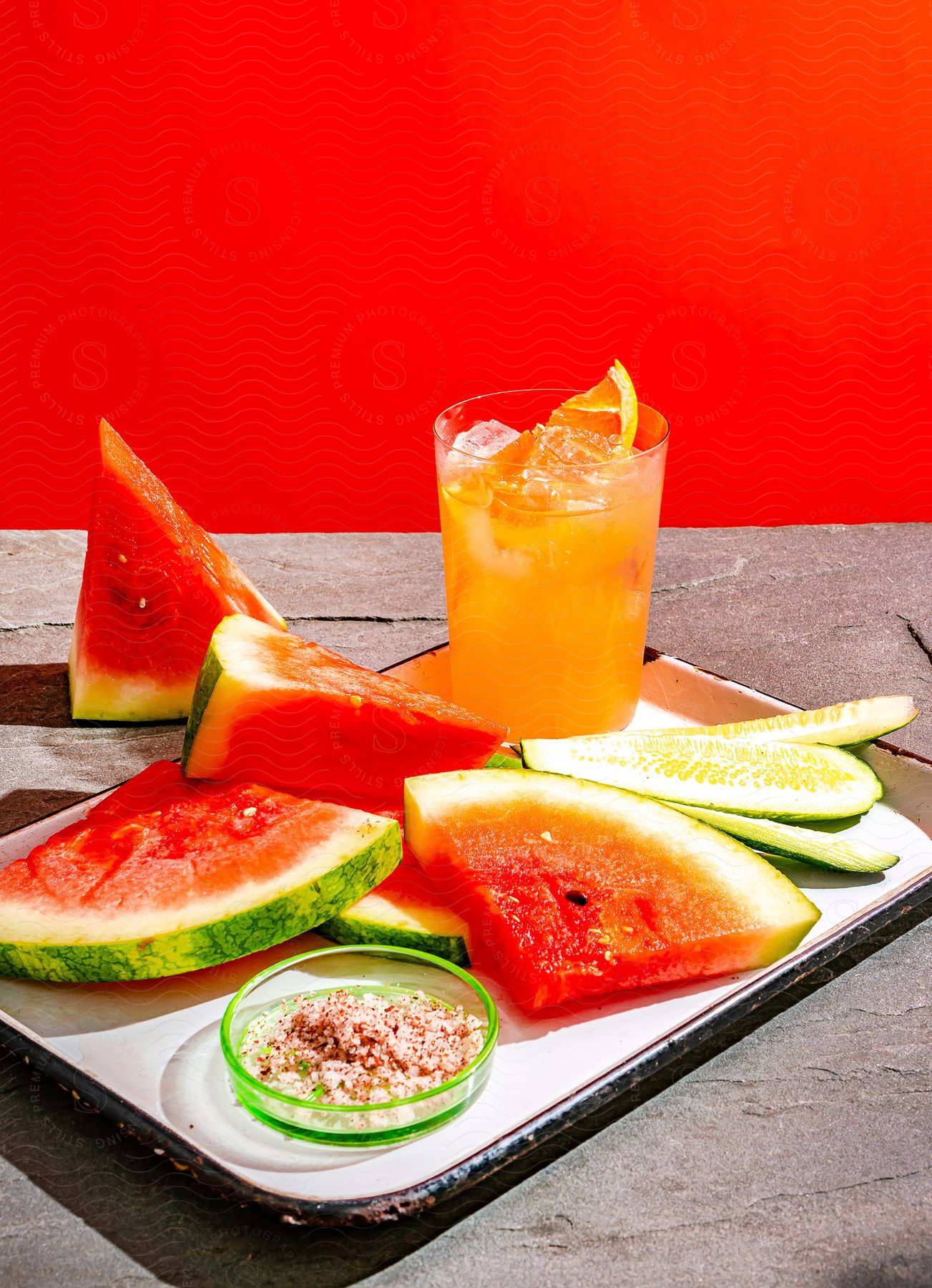 A plate of food and a cup of drink with melon and citrus