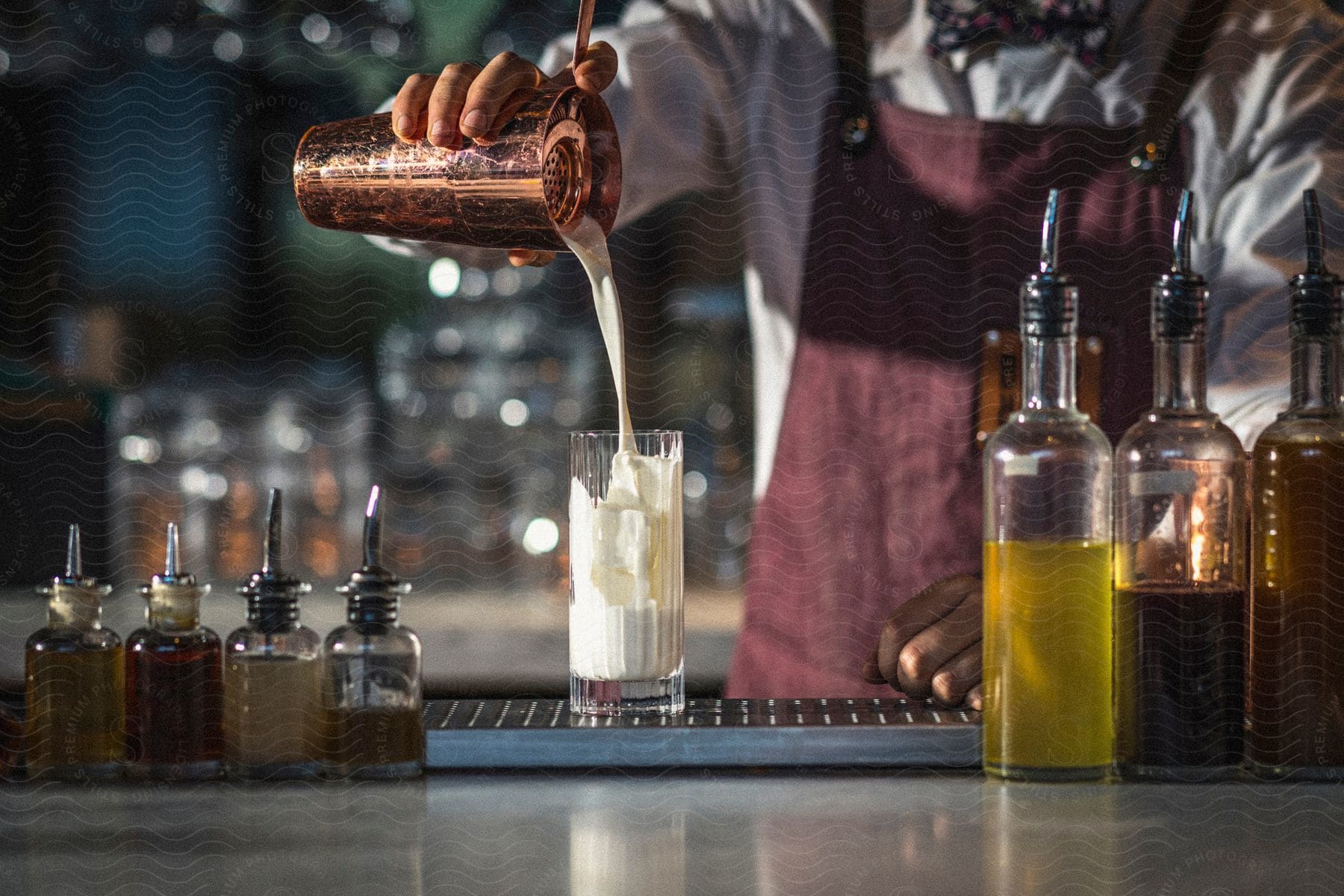 A Person Mixing Milk In A Glass Cup At A Bar