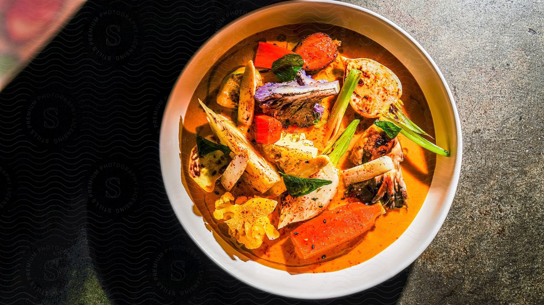 A bowl of soup with various vegetables