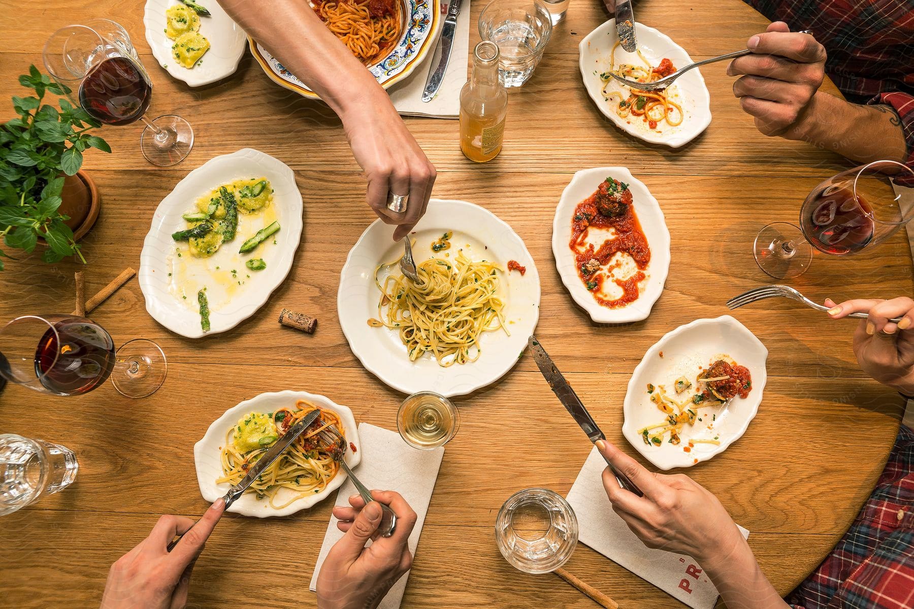 People enjoying plates of spaghetti at a table