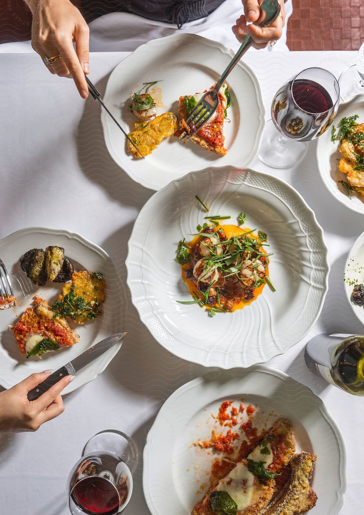 People eating with utensils from a table of food