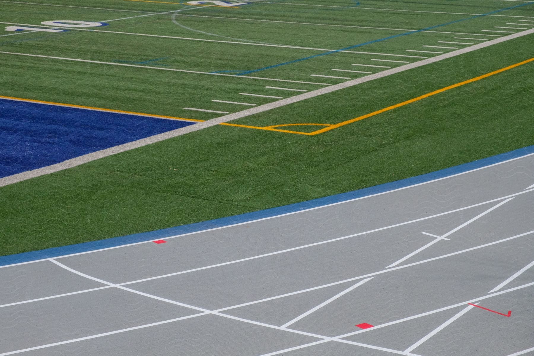 A 10 yard line on a football field with a grey running track outside