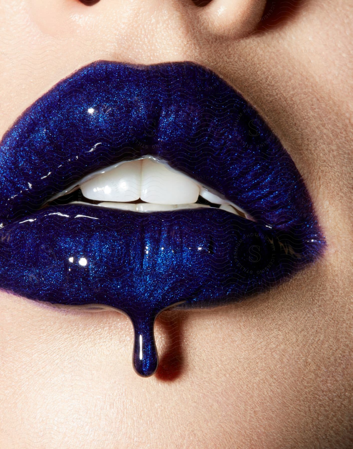 Close up of womans lips with blue lipstick dripping off