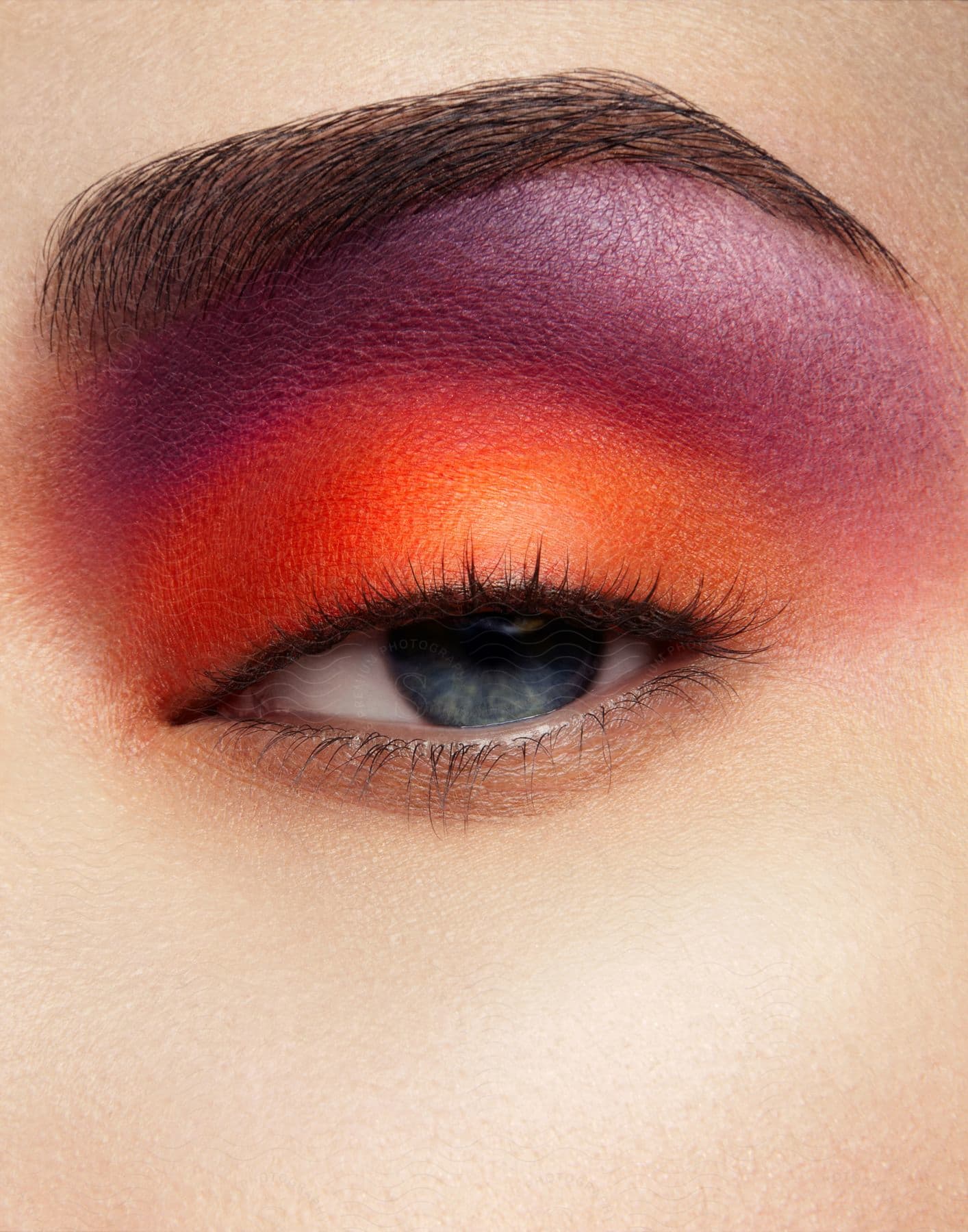 Close up of eye with orange and purple eye makeup