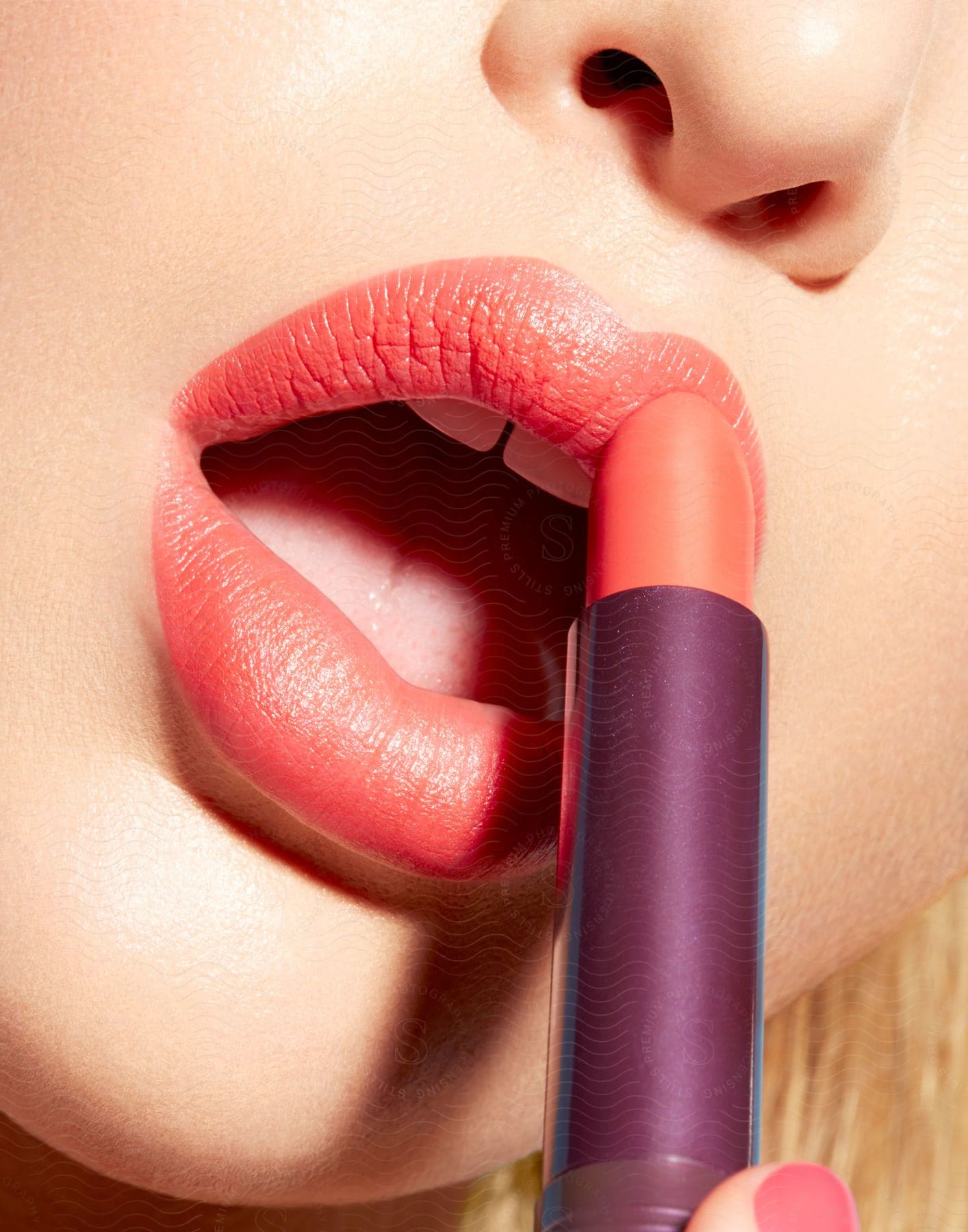 A woman applies lipstick directly from the tube