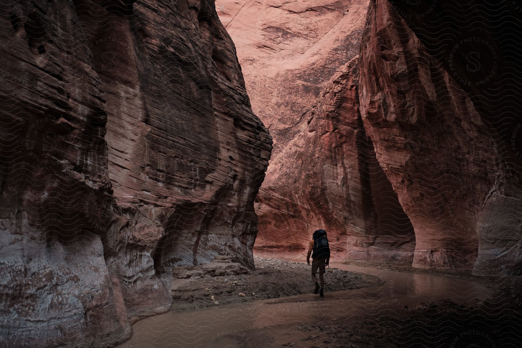 A person exploring a natural landscape with canyons and a lake