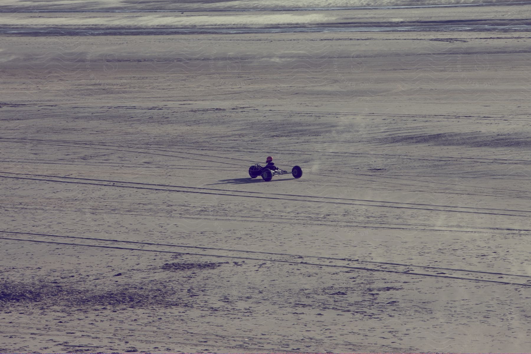 Desert landscape with body of water and a motor vehicle