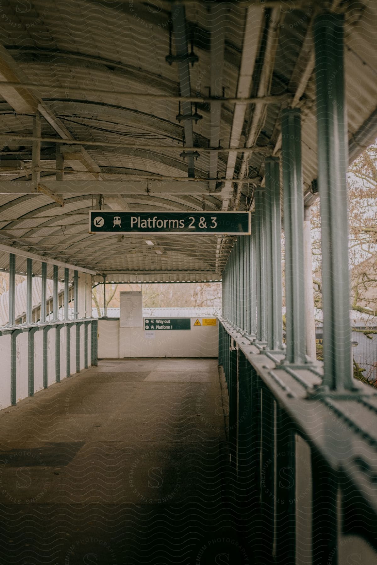 A sign hangs in an openwalled terminal indicating the direction to two platforms