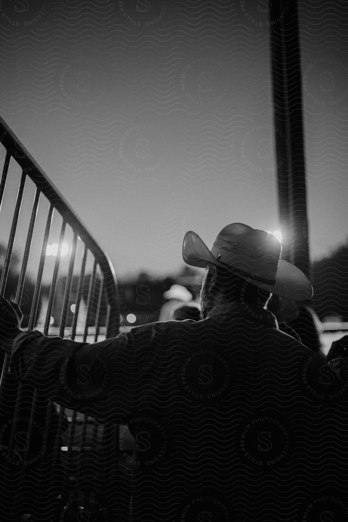 A man wearing a cowboy hat outdoors at night