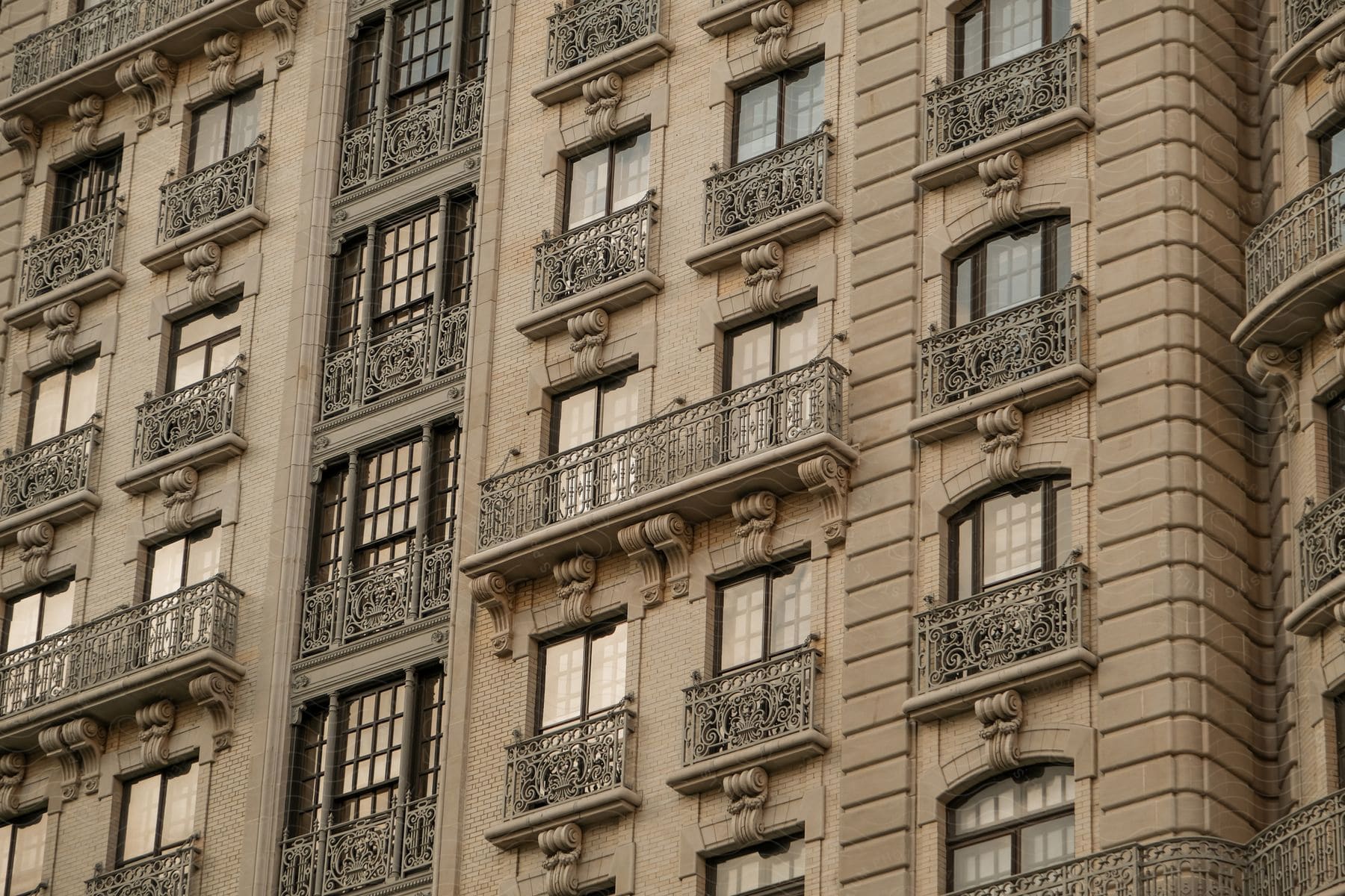 An ornate stone apartment building with wrought iron balconies