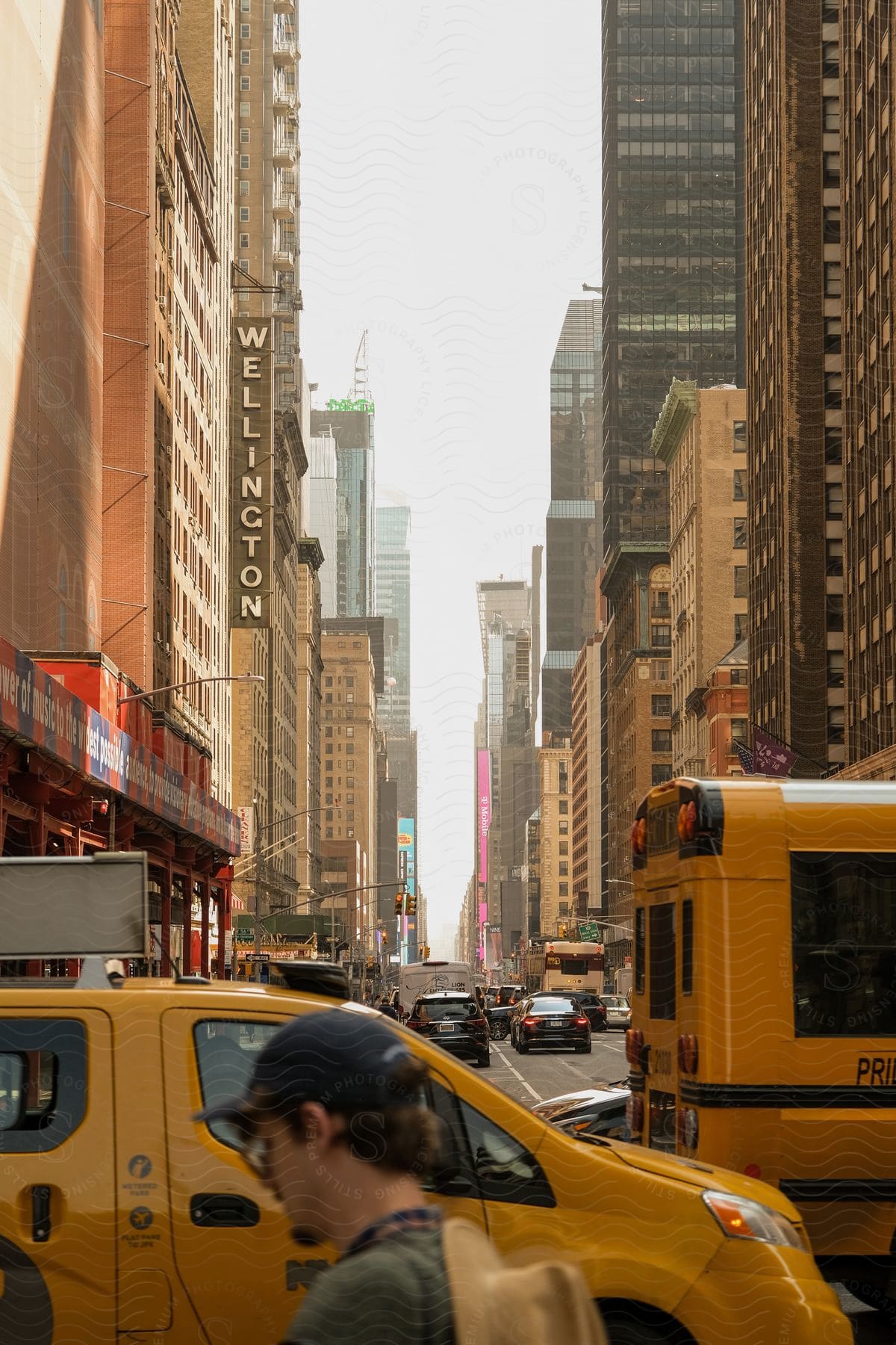 A man stands in a city street surrounded by buildings and traffic