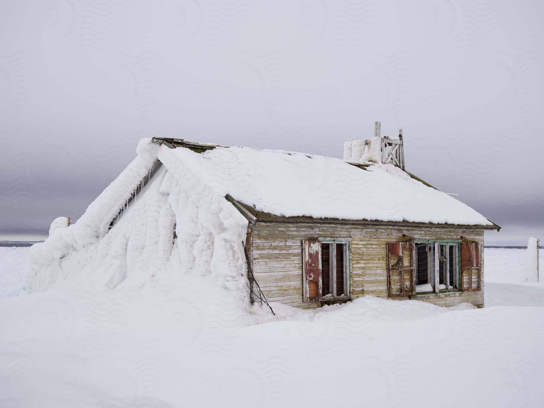 Snowcovered wooden cabin in a snowy field