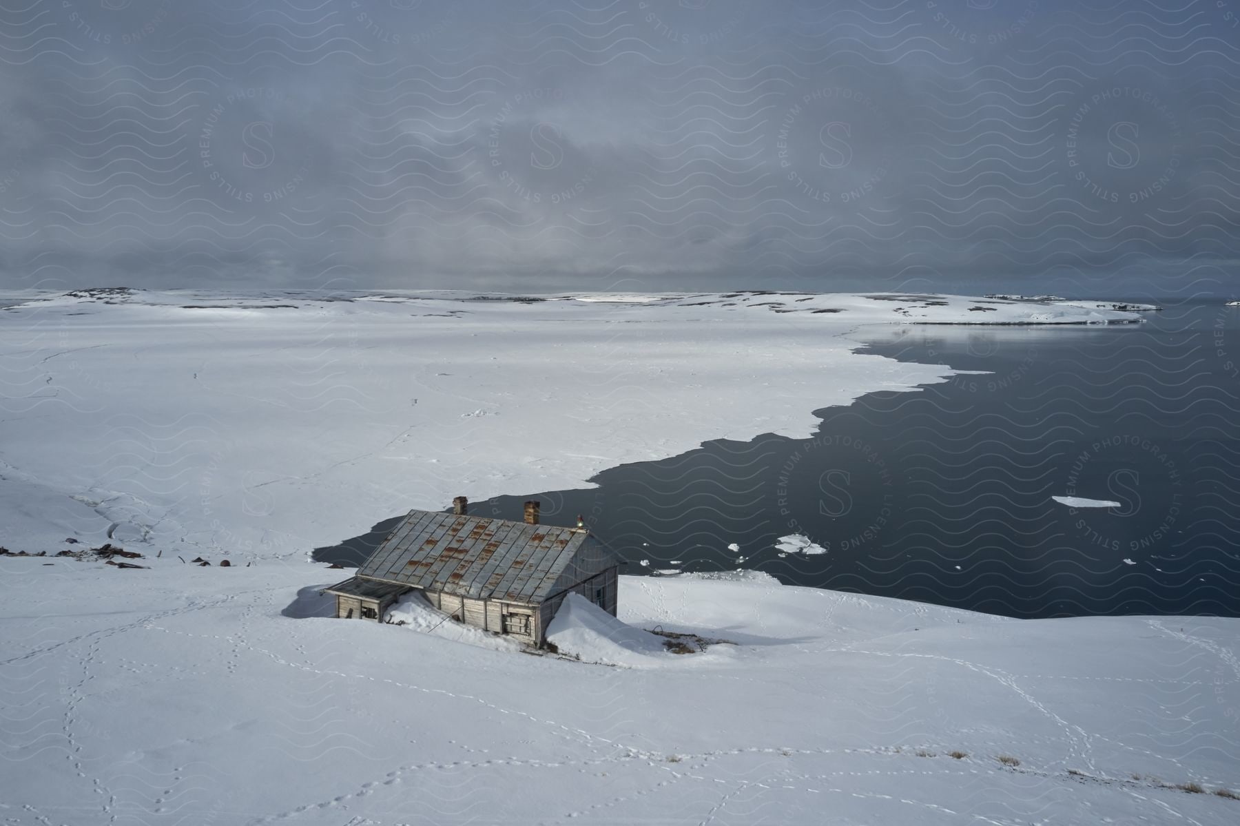 A log cabin in a coastal landscape with the ocean on the horizon