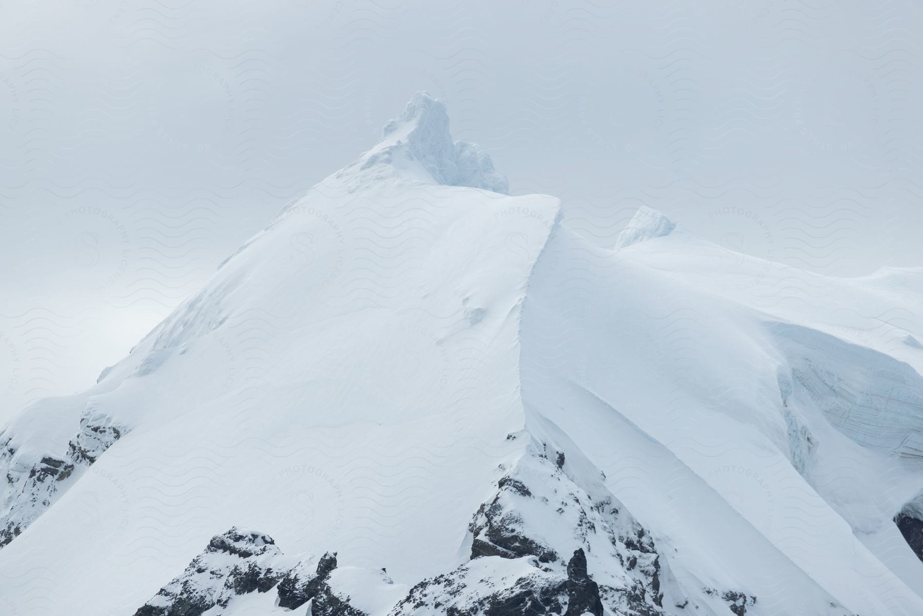 A snowcovered mountain stands against a cloudy sky