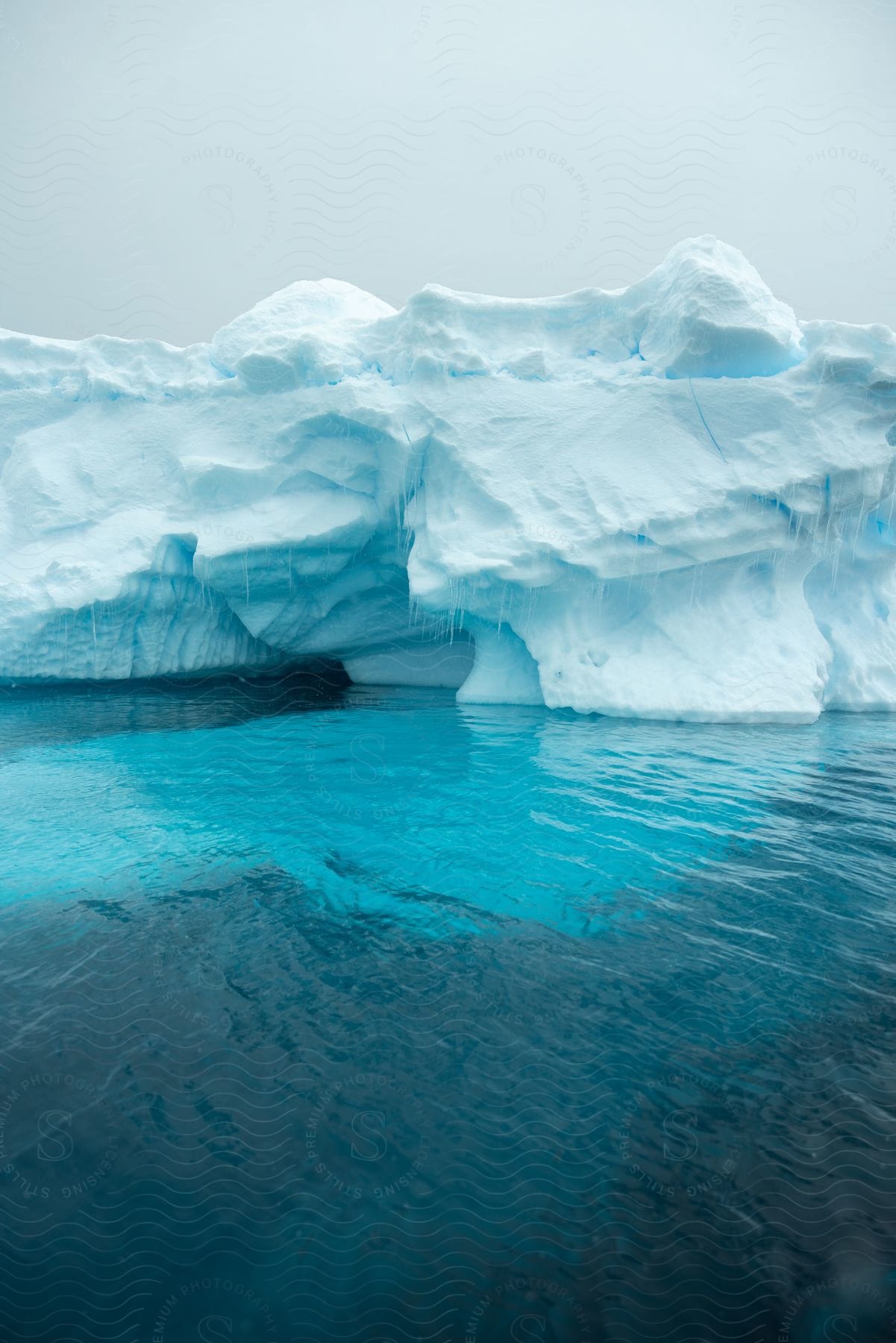 An iceberg forming a tiny cave on blue water