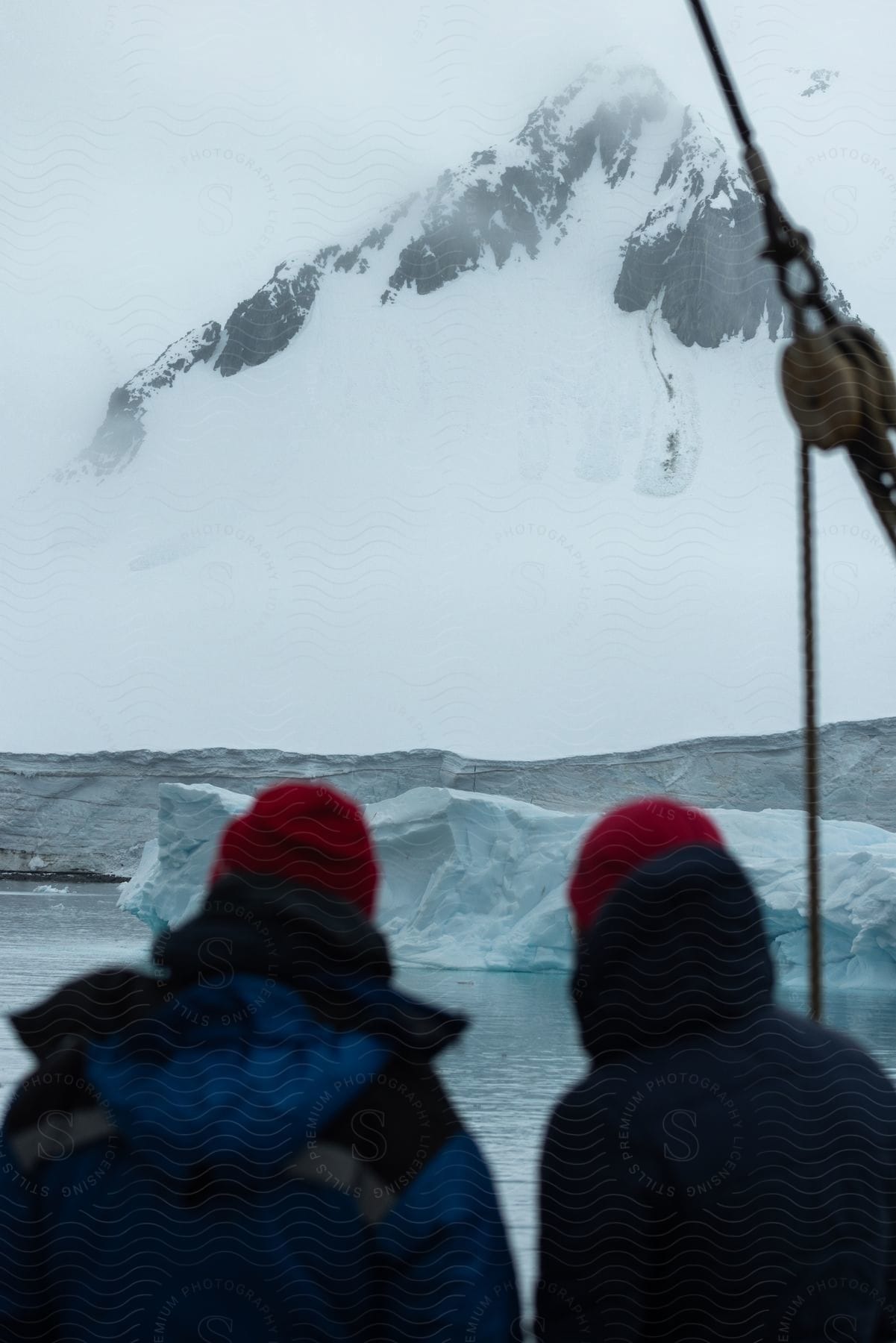 Two men standing on a snowy mountain in antarctica