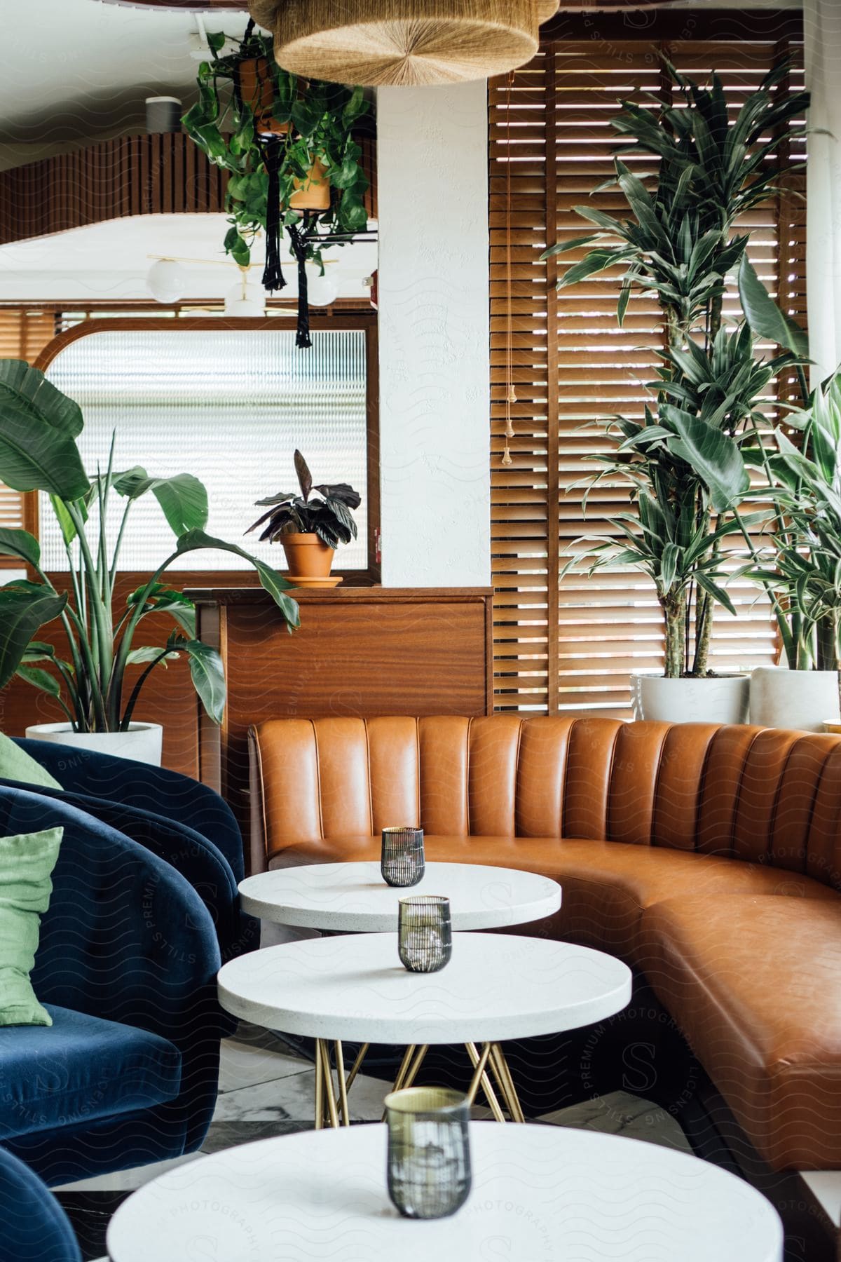 An appointed living room with tables chairs a couch and plants