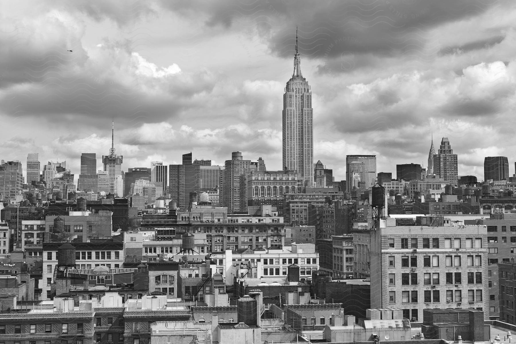 Empire state building towering over new york cityscape under cloudy skies