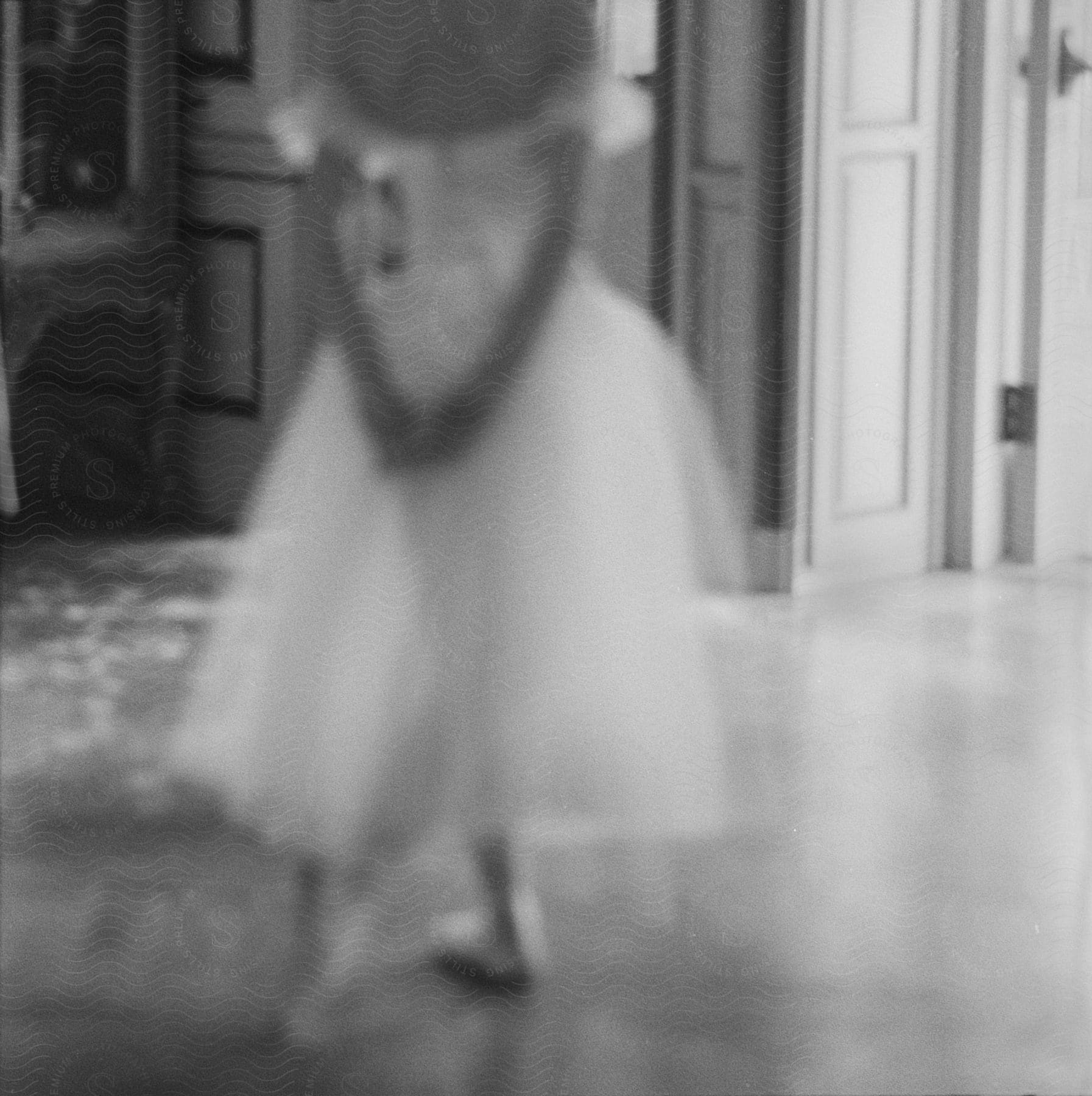 A young girl in a dancers dress standing with her hands behind her back