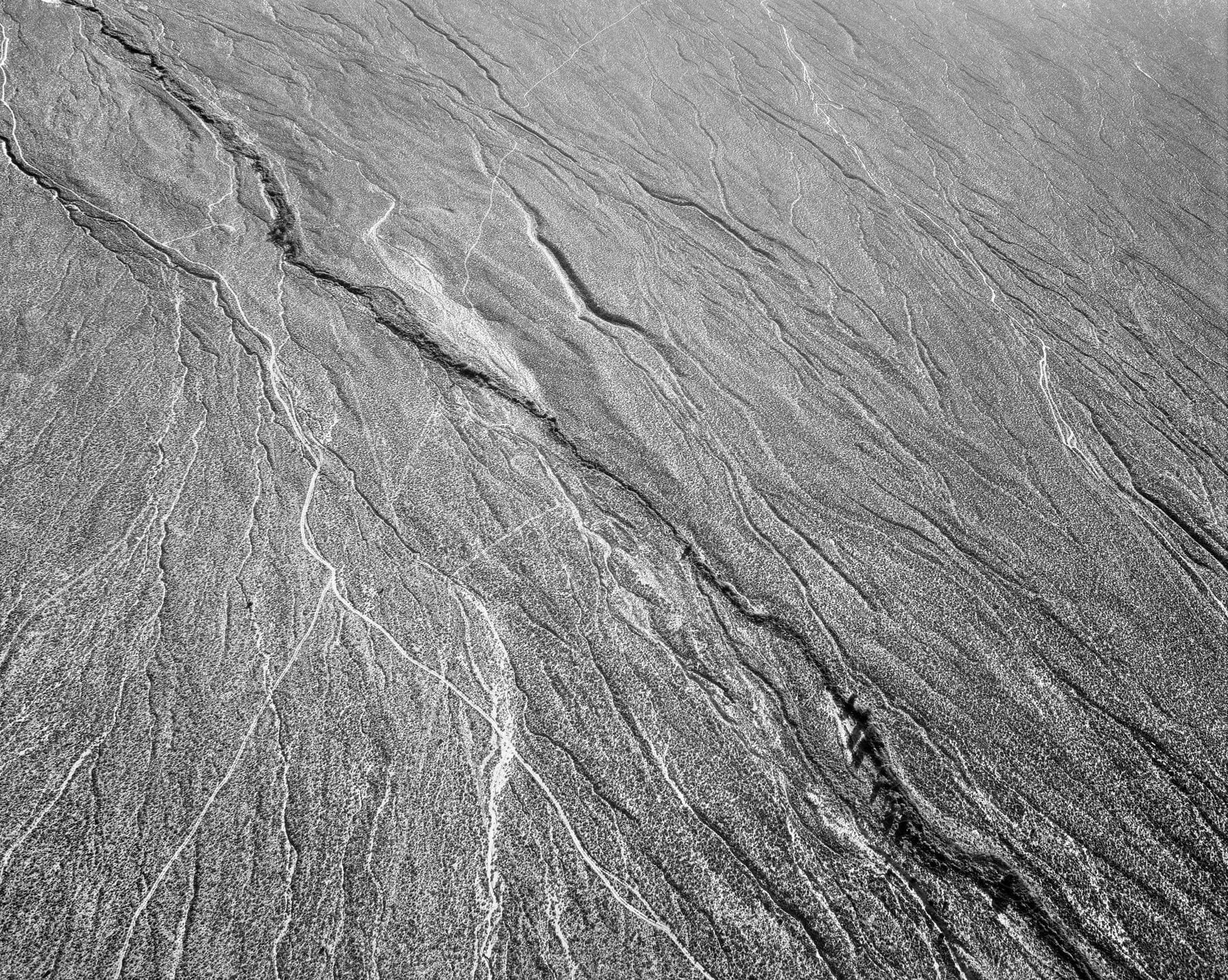 Dry barren desert seen from above in black and white