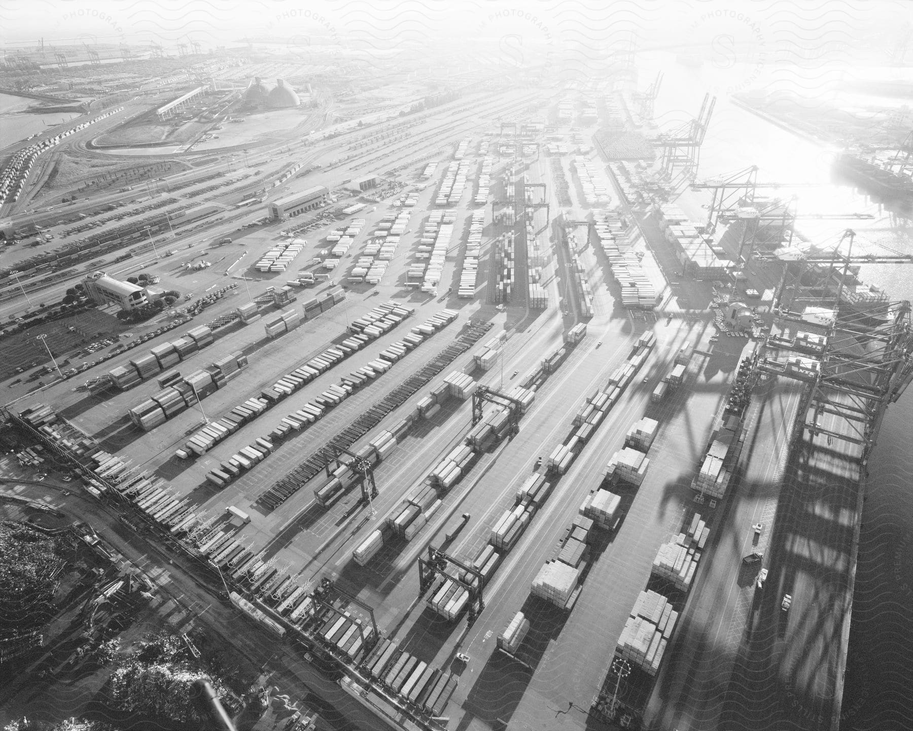 Aerial view of a shipping container port and yard filled with containers in black and white