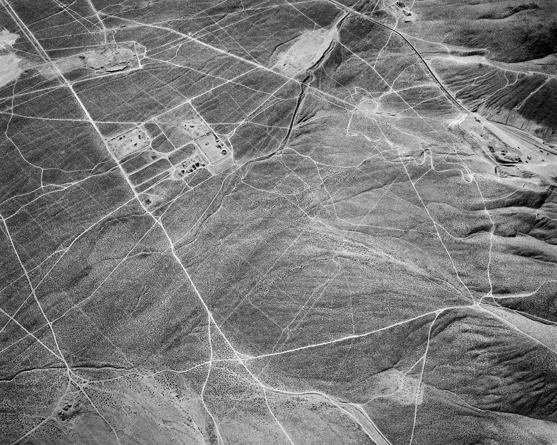 A blackandwhite aerial view of a grey soil field