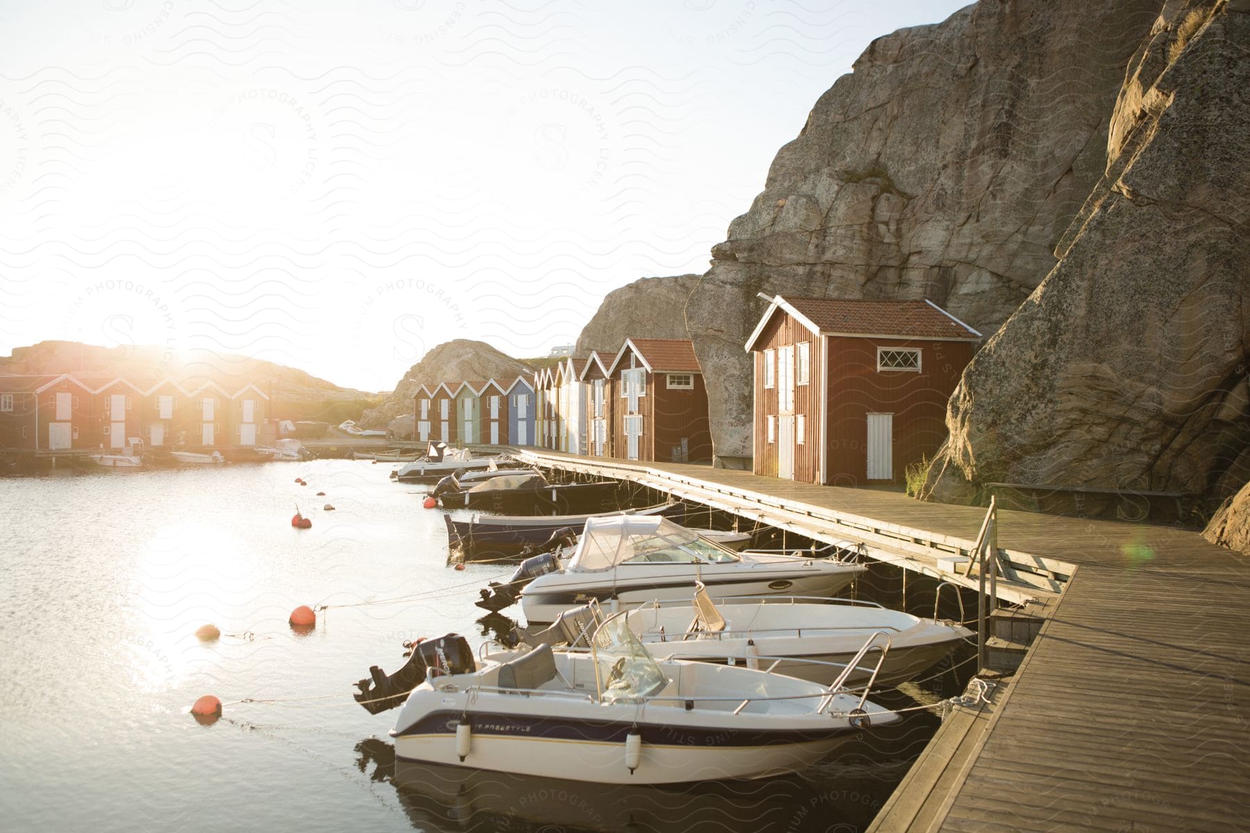 A waterfront harbor with boats and buildings at dusk or dawn