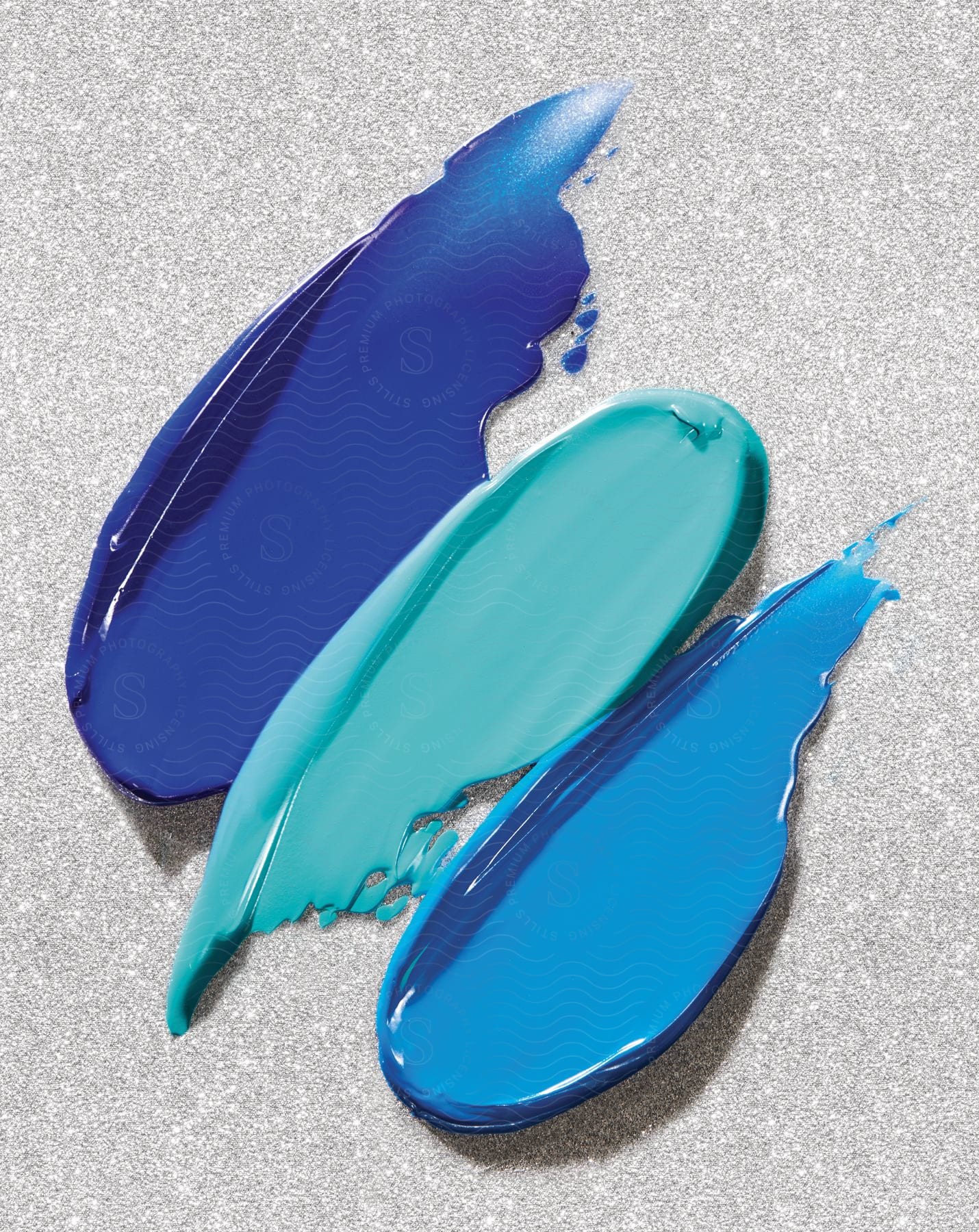 Three colors of paint placed on a flat surface