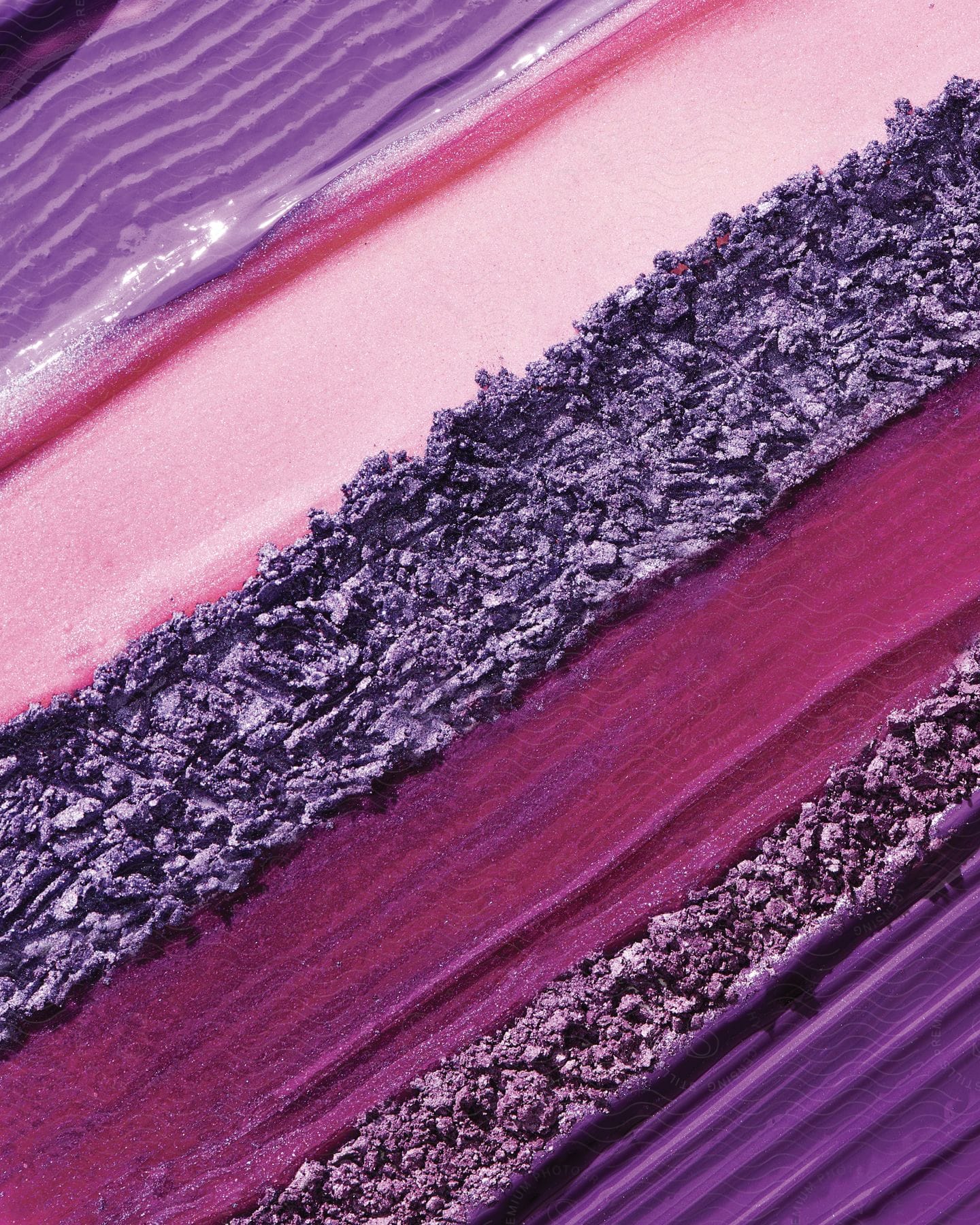 Stripes of purple creams or paints spread on a textile rectangle