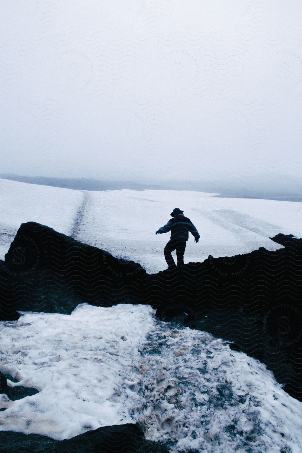 A man hiking in nature with mountains and water in the background