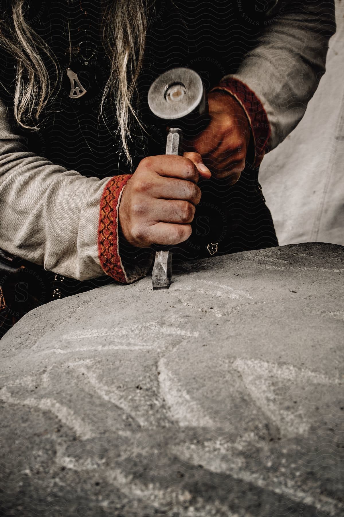 Male hand chiseling stone