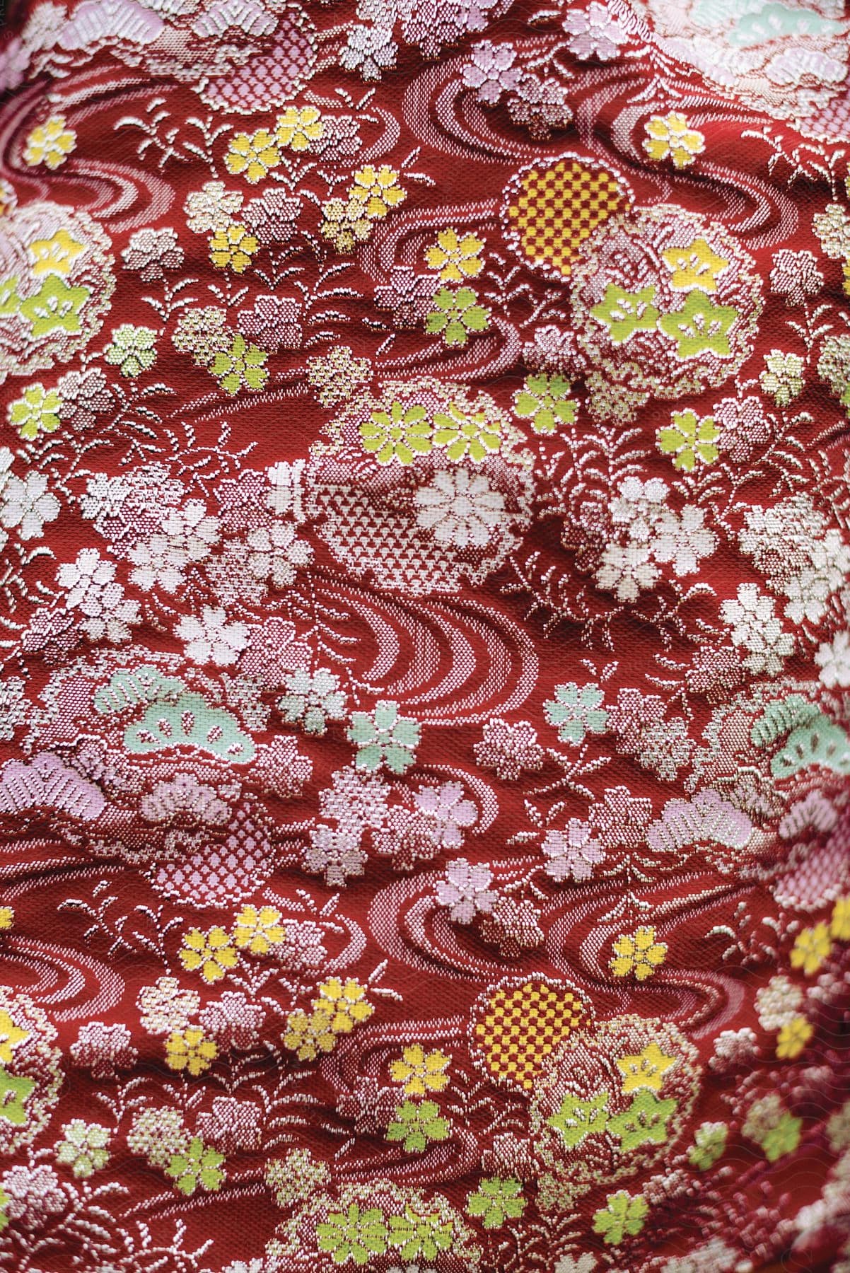 A red and yellow floral print fabric with a white and yellow flower design