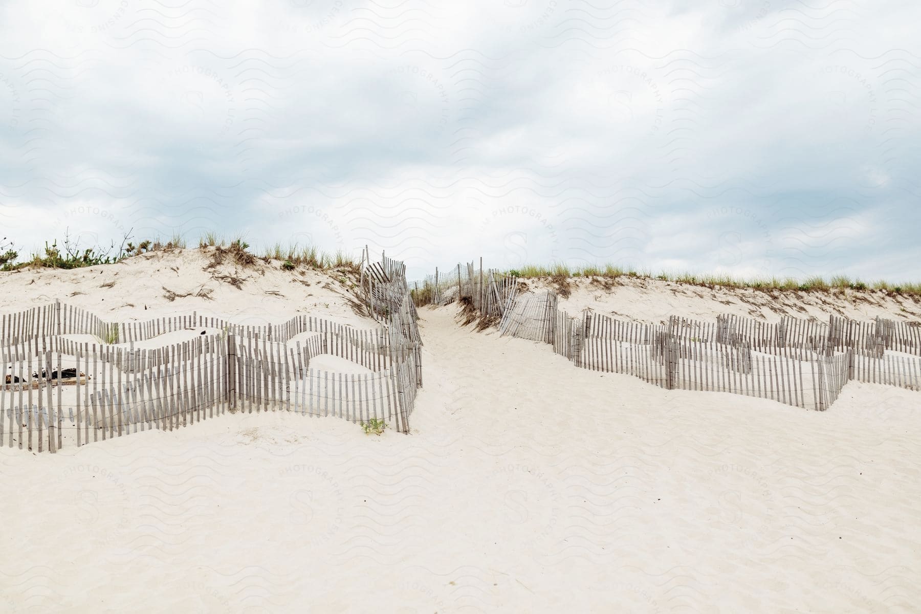 A large sandy land with a white picket fence surrounding it