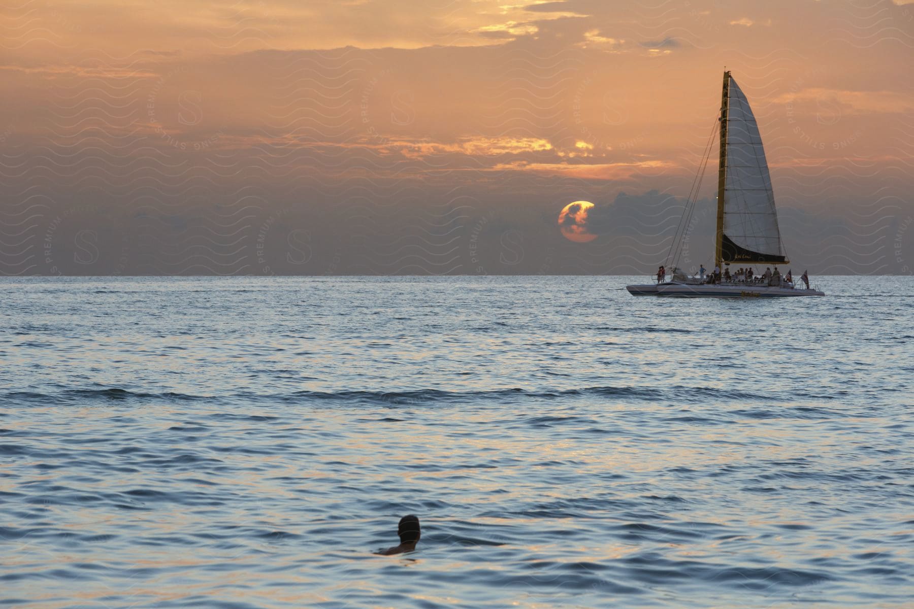 One person in a boat on a calm lake at sunset