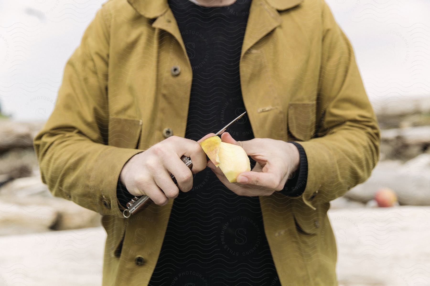 A person cutting an apple in a flat landscape