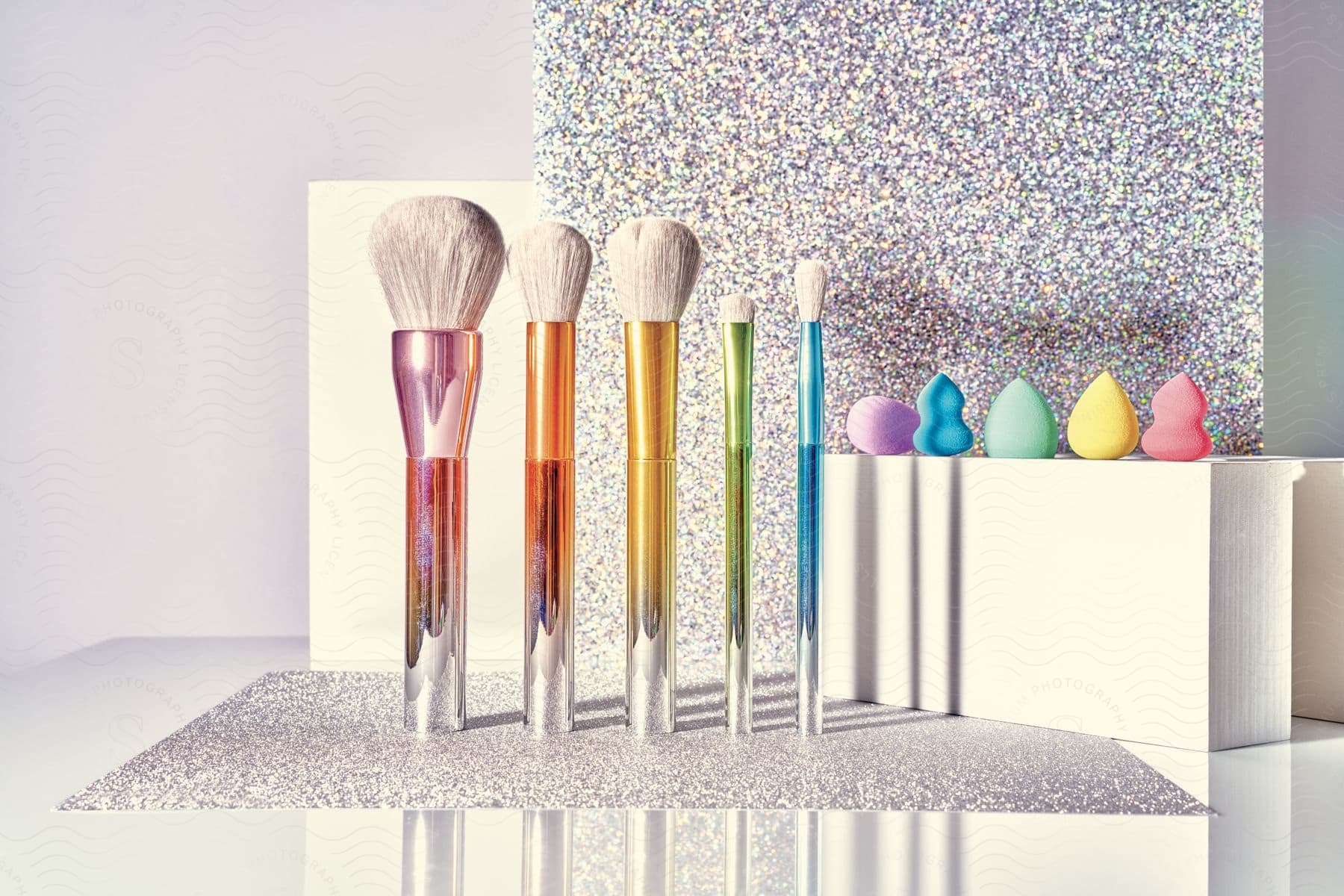 Makeup brushes and sponge applicators arranged in rainbow color order