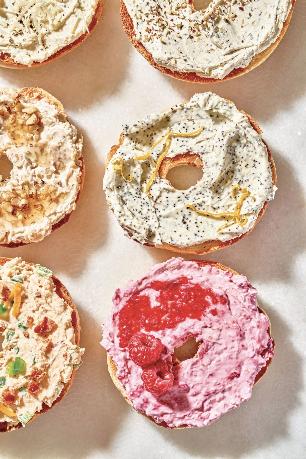 A Variety Of Cream Cheese Covered Bagels Garnished With Fruit