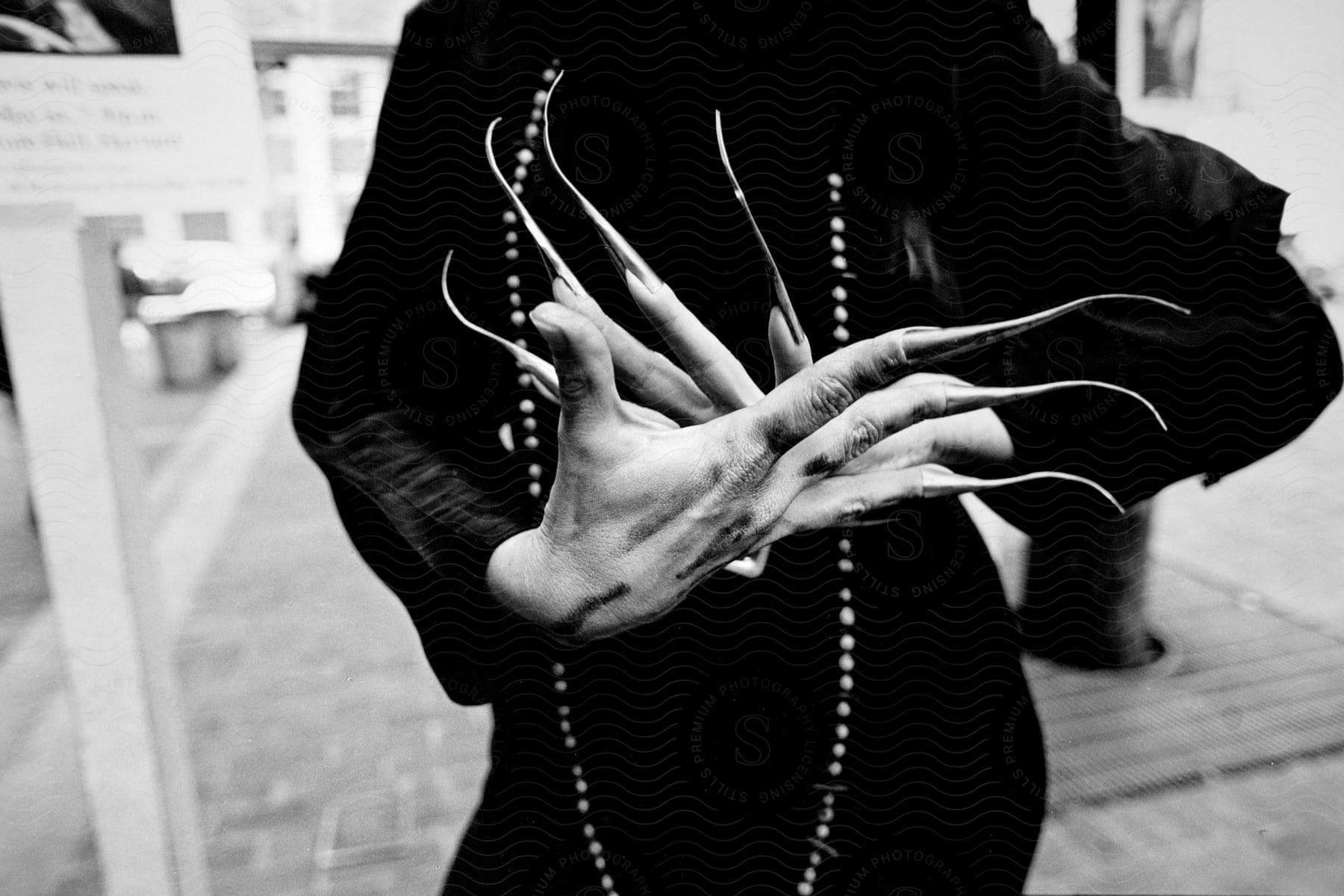 A persons hands with long blackpainted nails