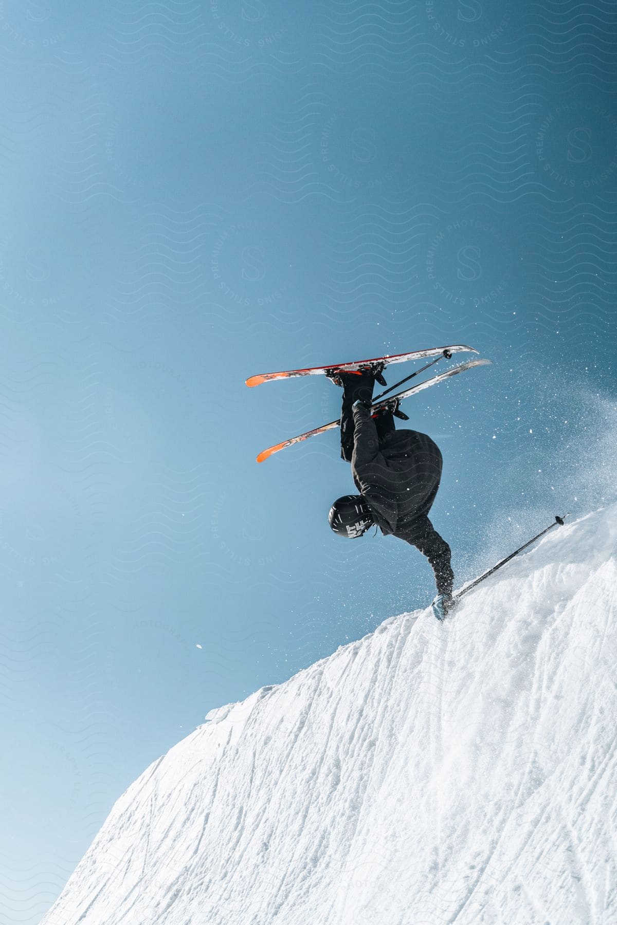 A man is skiing and performing a trick on a snowy slope in the austrian alps