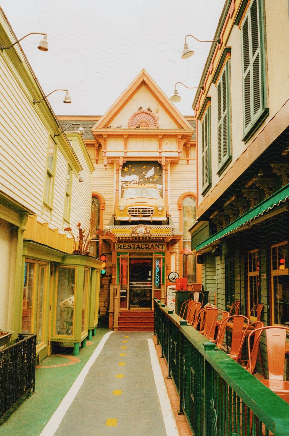 A colorful seafood restaurant stands at the end of a path with other colorful buildings