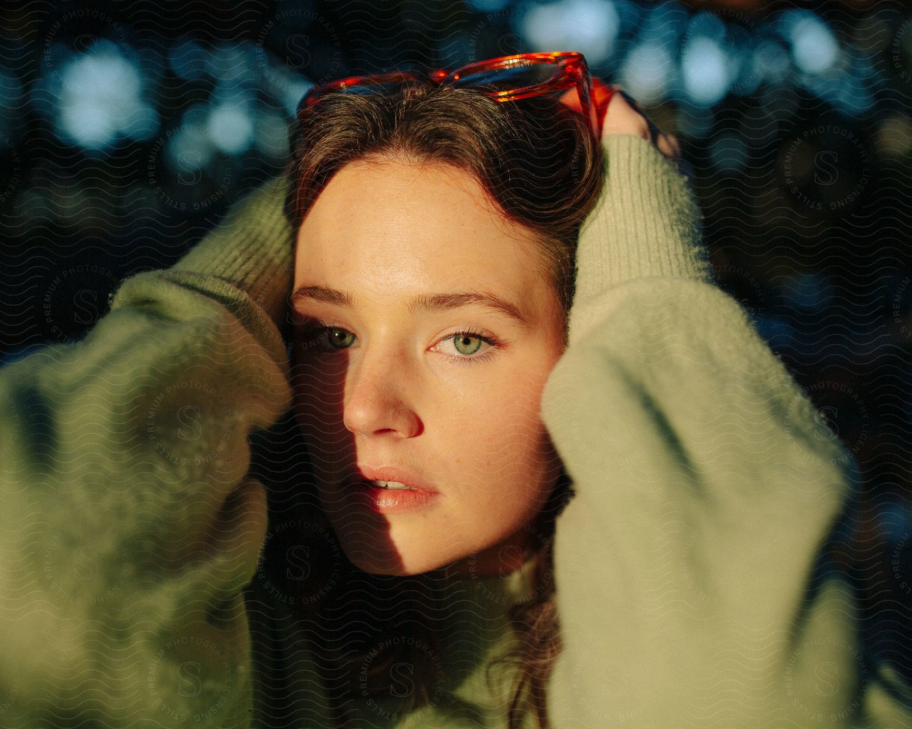 A woman wearing sunglasses and a sweater with a happy expression on her face