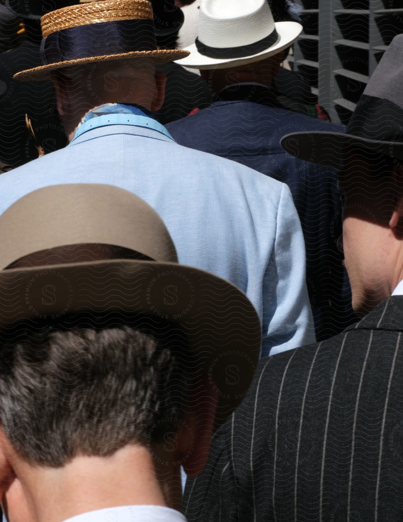 A group of men wearing hats and suits walking