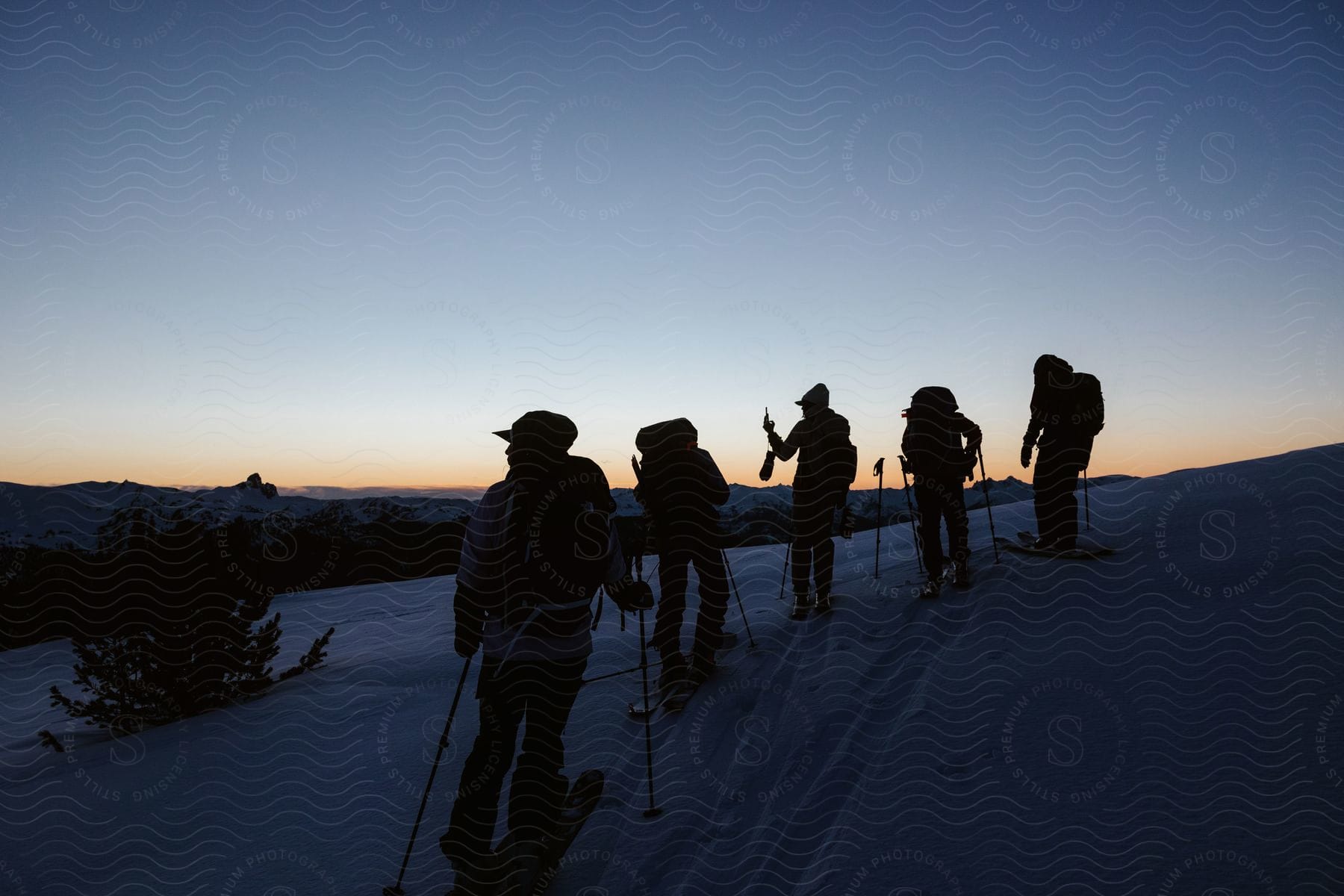 Hikers Reach Mountain Peak At Sunset Greeted By Snowcovered Slopes And Skis Ready For Thrilling Hike