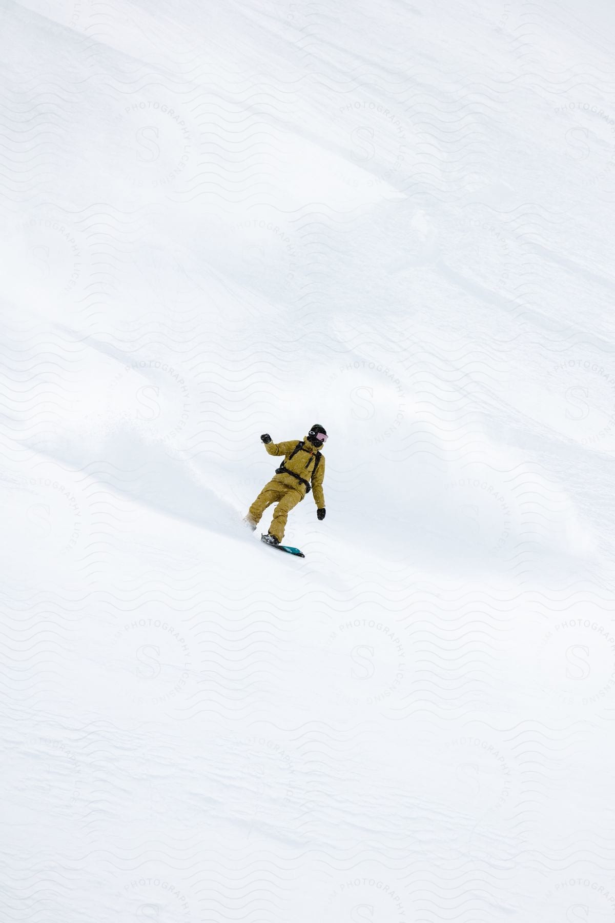 A man snowboards down a snowcovered mountainside