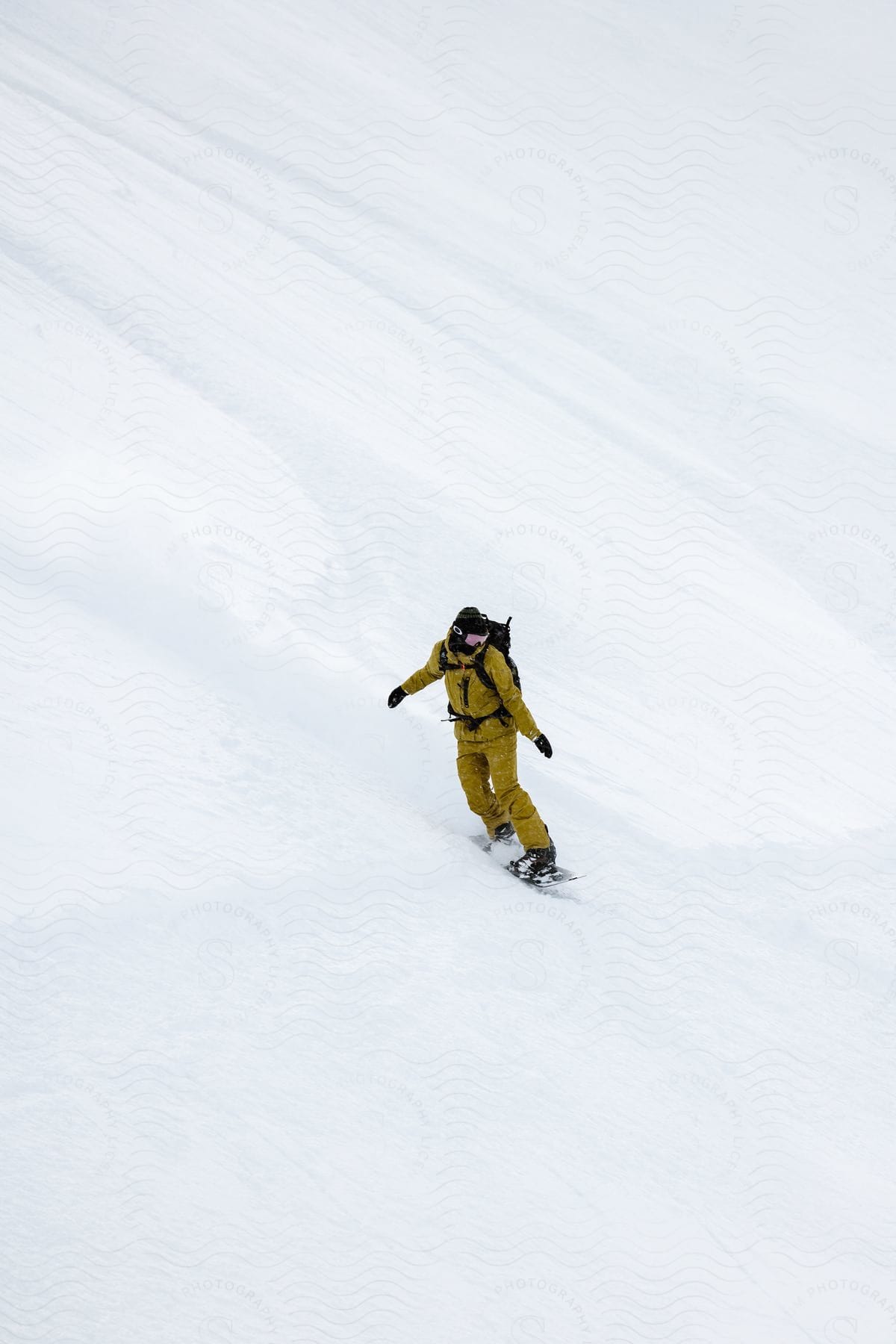 A man snowboards down a snowcovered mountain slope