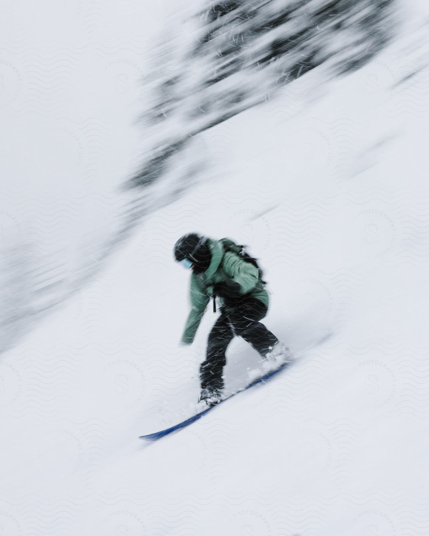 A man snowboards down a snowcovered mountainside