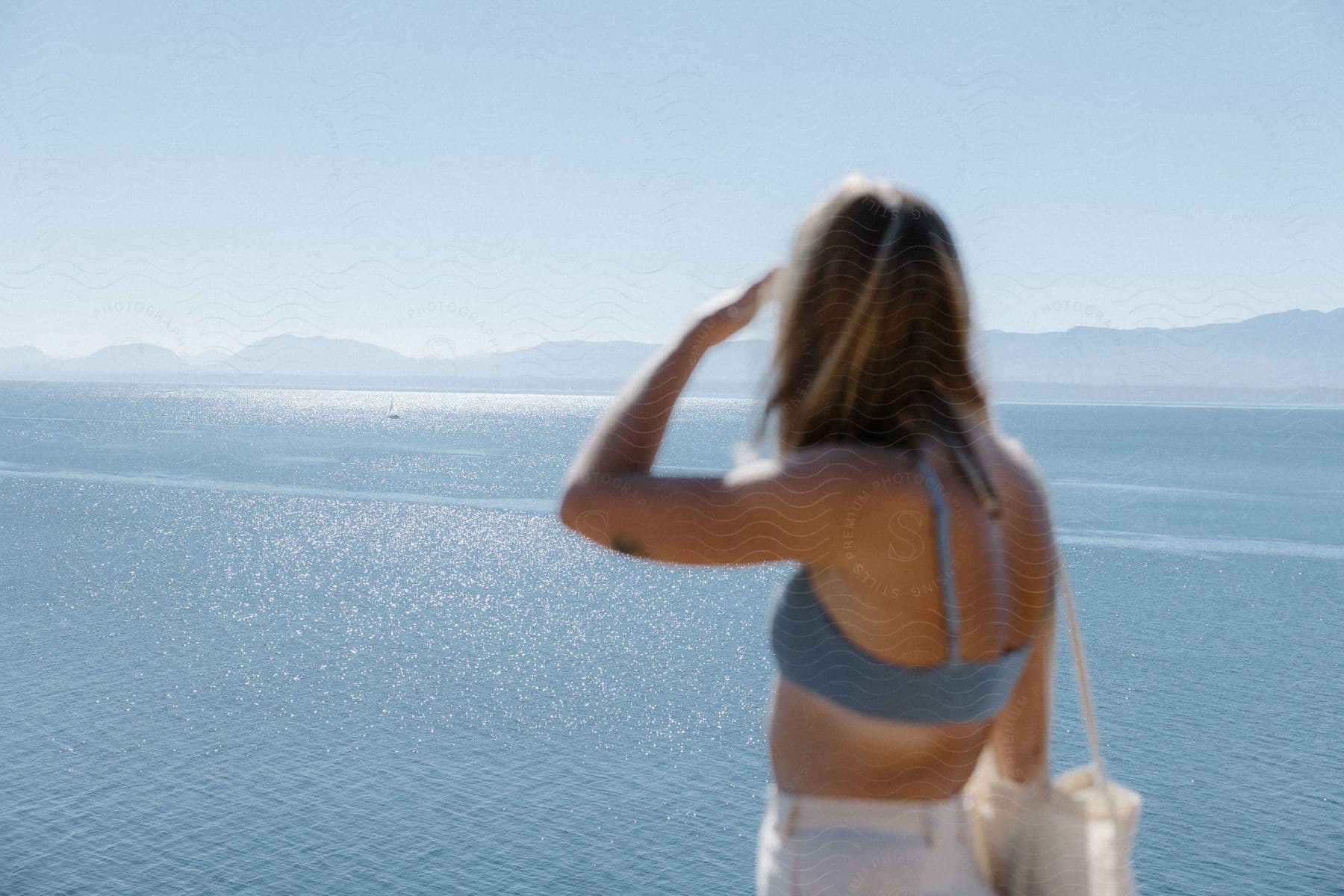 A woman gazes at the sea horizon