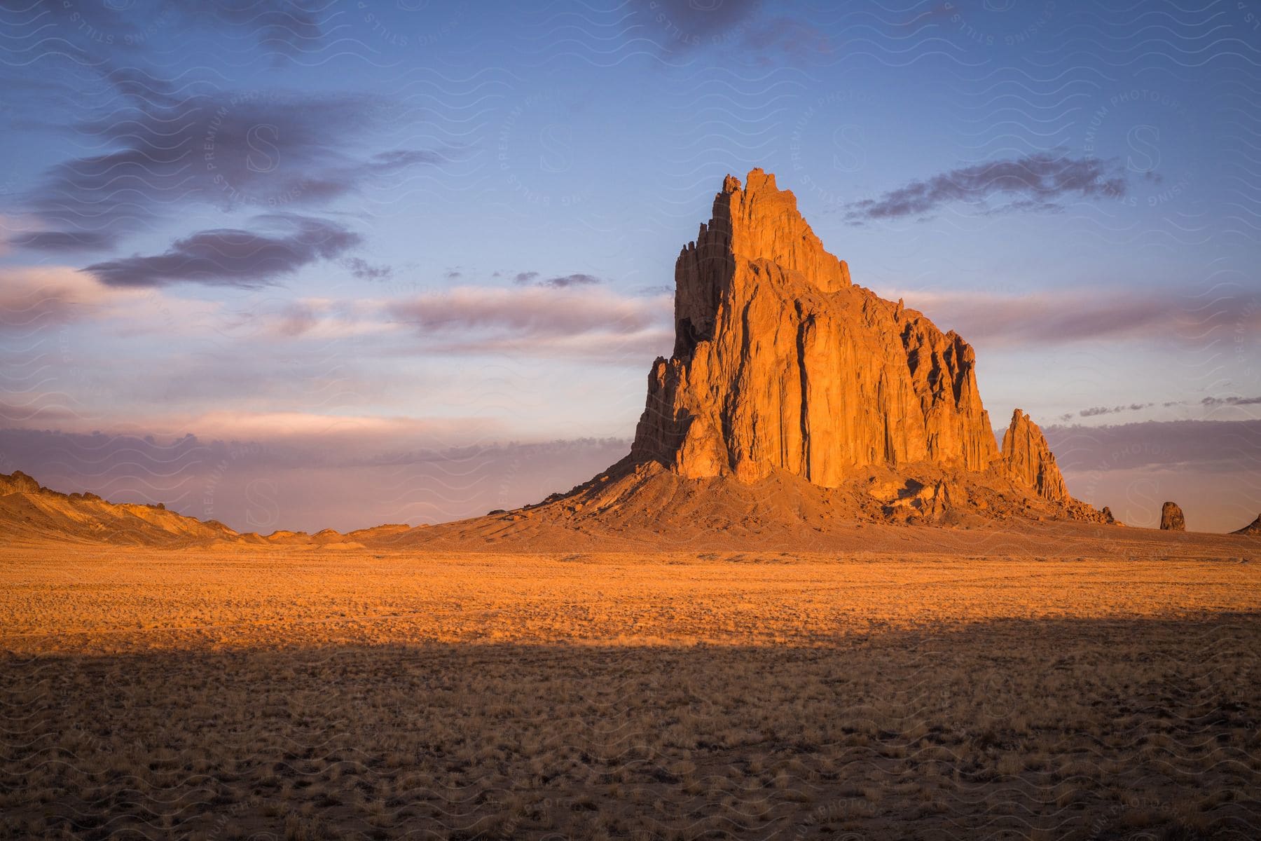 A serene mountain landscape at dusk with a cloudy sky