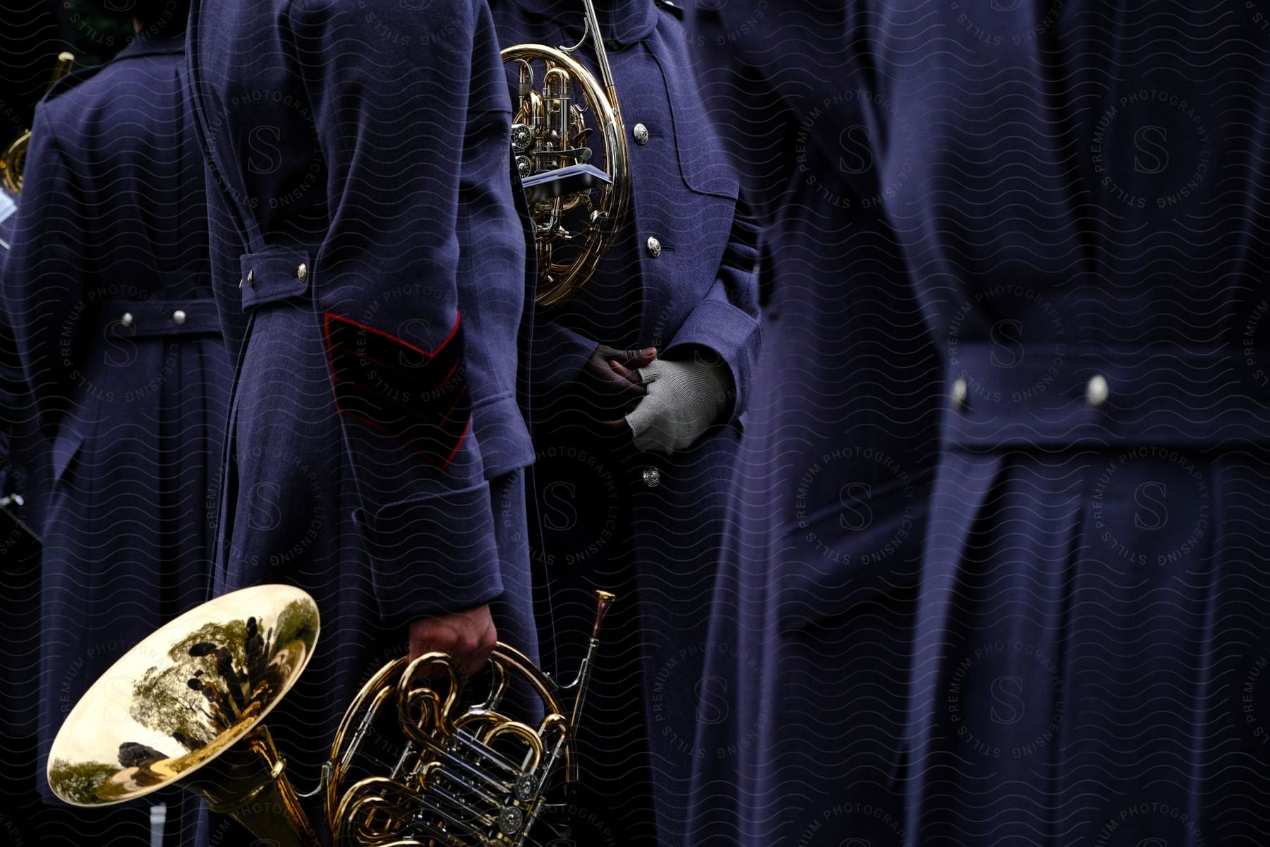 A group of musicians wearing formal uniforms and playing various instruments including french horns